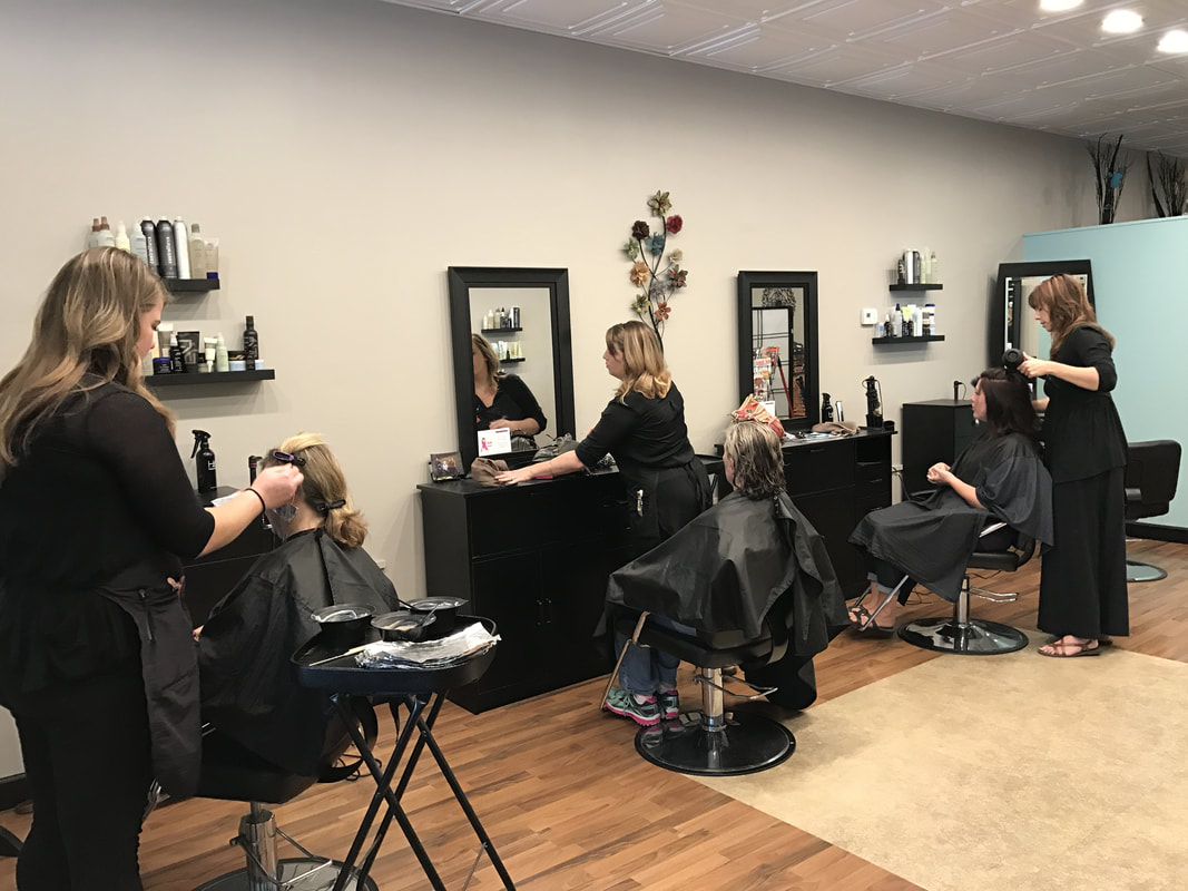 Three women receiving hair treatments at a modern beauty salon