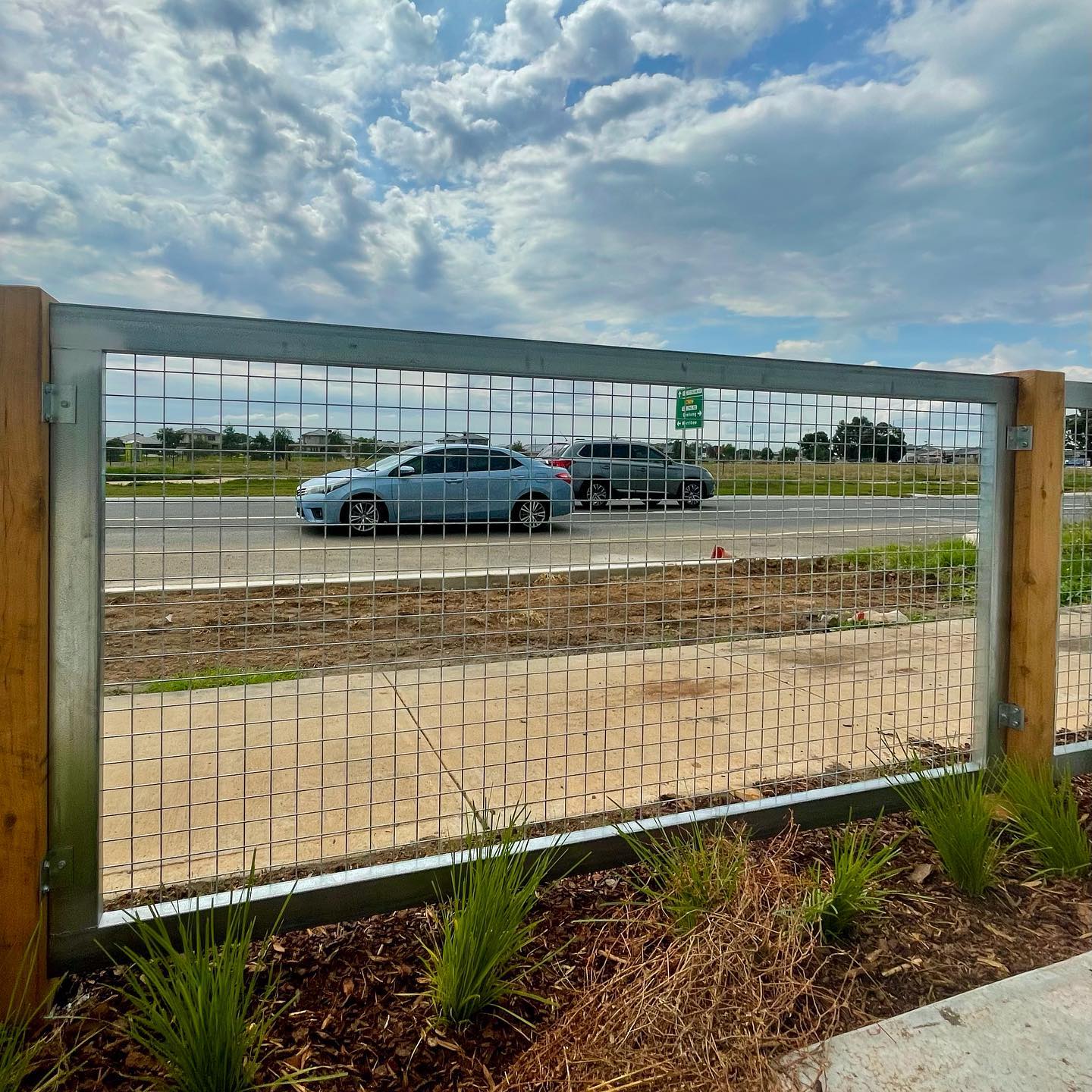 Custom Raw Galvanized Wire Sheets in Hoppers Crossing: A Unique and Flashy Installation 4 Section of fence alongside road with visible traffic