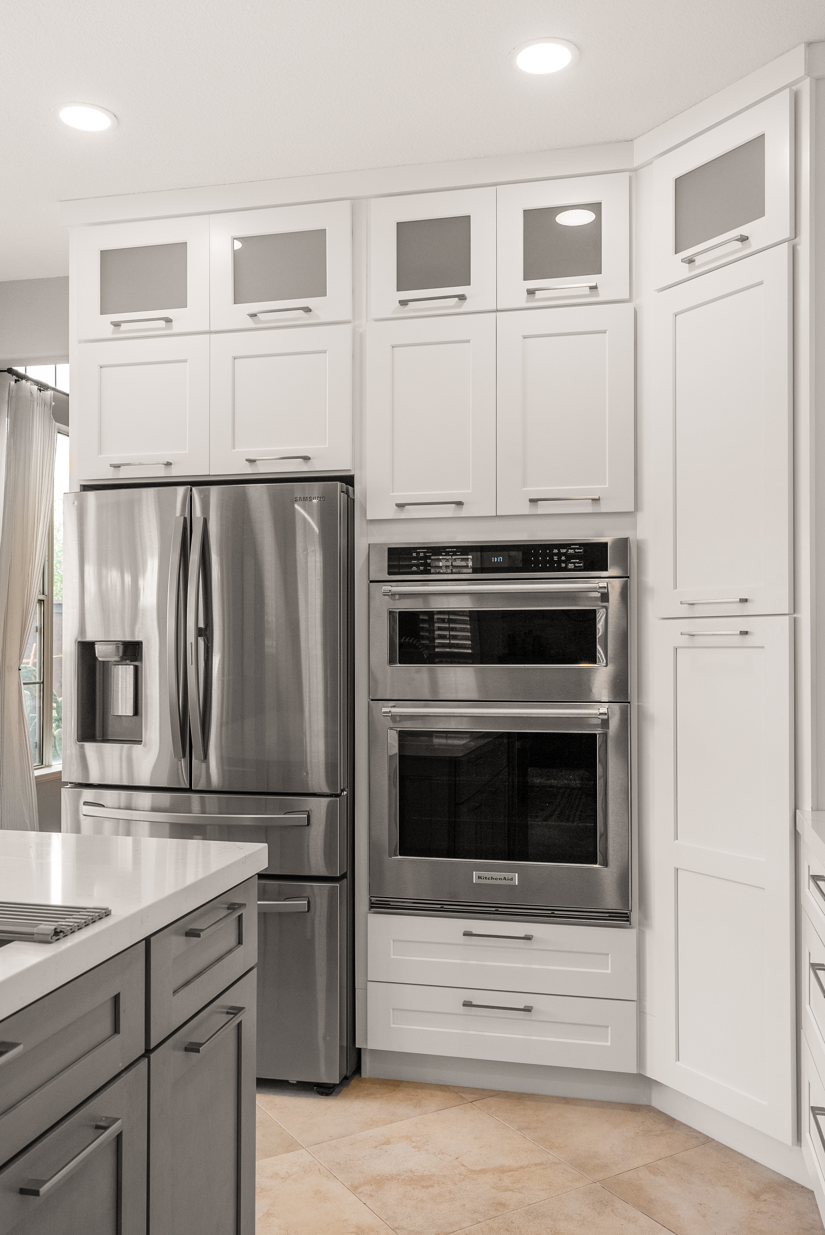 Stainless steel refrigerator and built-in double oven in remodeled kitchen