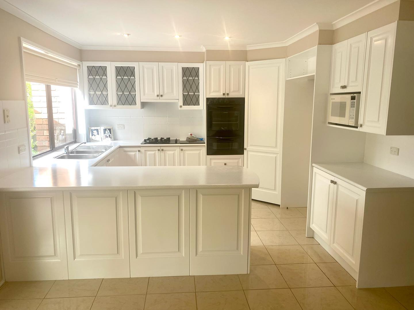 White kitchen cabinets with raised panel doors after resurfacing