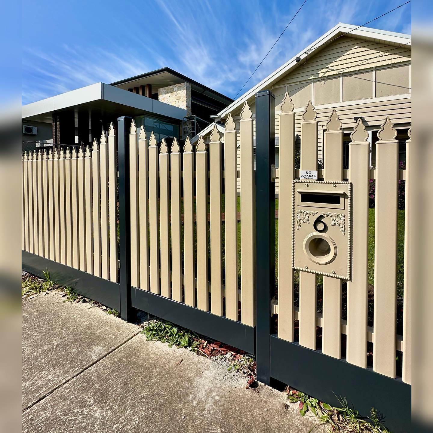 Elegant beige metal fence with black vertical support posts