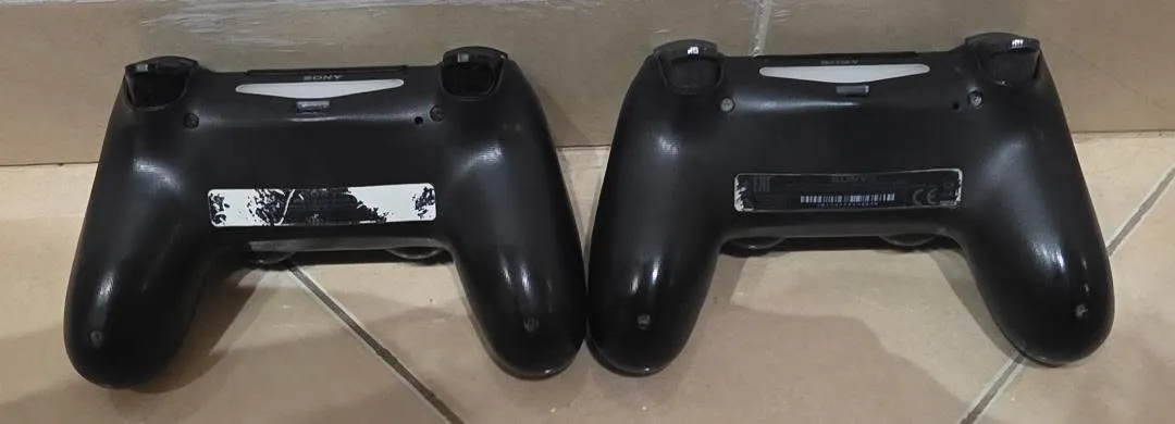 Два черни безжични контролера Sony DualShock 4 за PlayStation 4