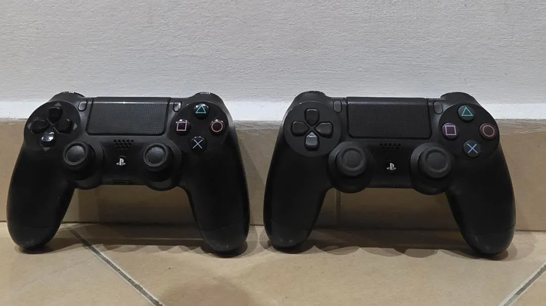 Два черни безжични контролера Sony DualShock 4 за PlayStation 4