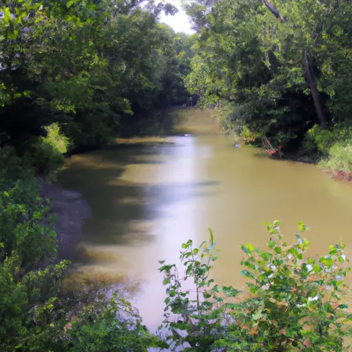 A picture of a long brown river with trees on either side