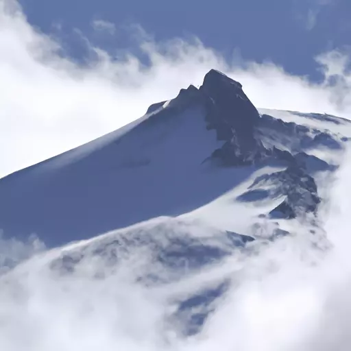 A picture of a snowy peak with a cloud in the background