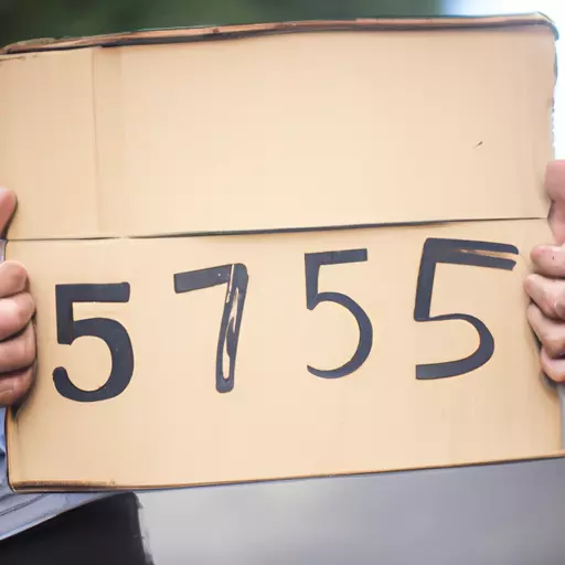 A picture of a hand holding five cardboards with digits written on them