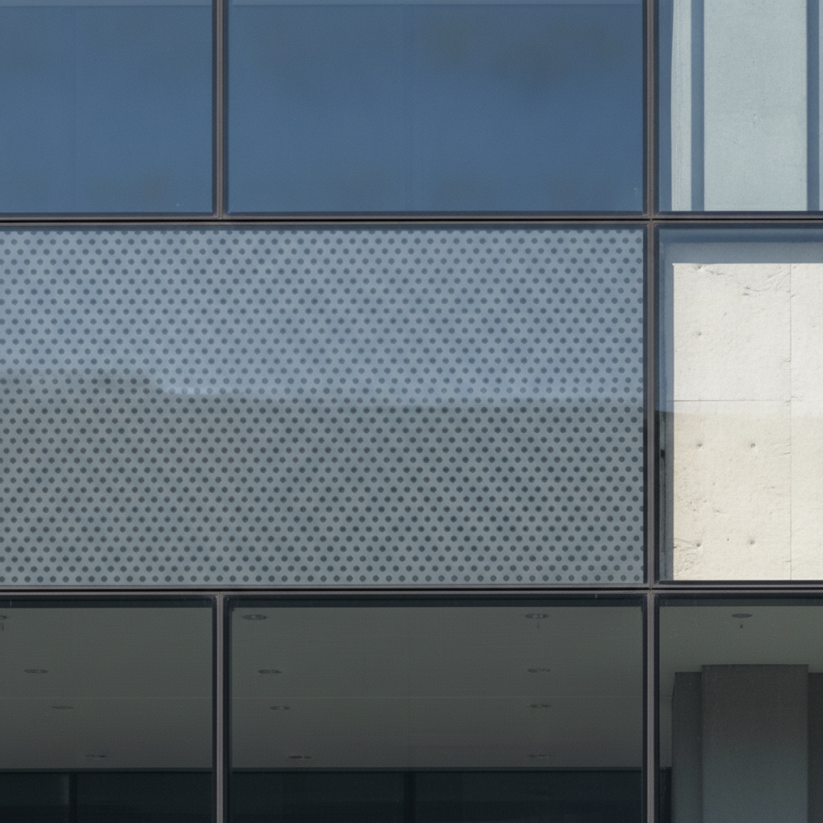 Opacified ceramic frit spandrel glass detail on commercial curtain wall with visible substrate