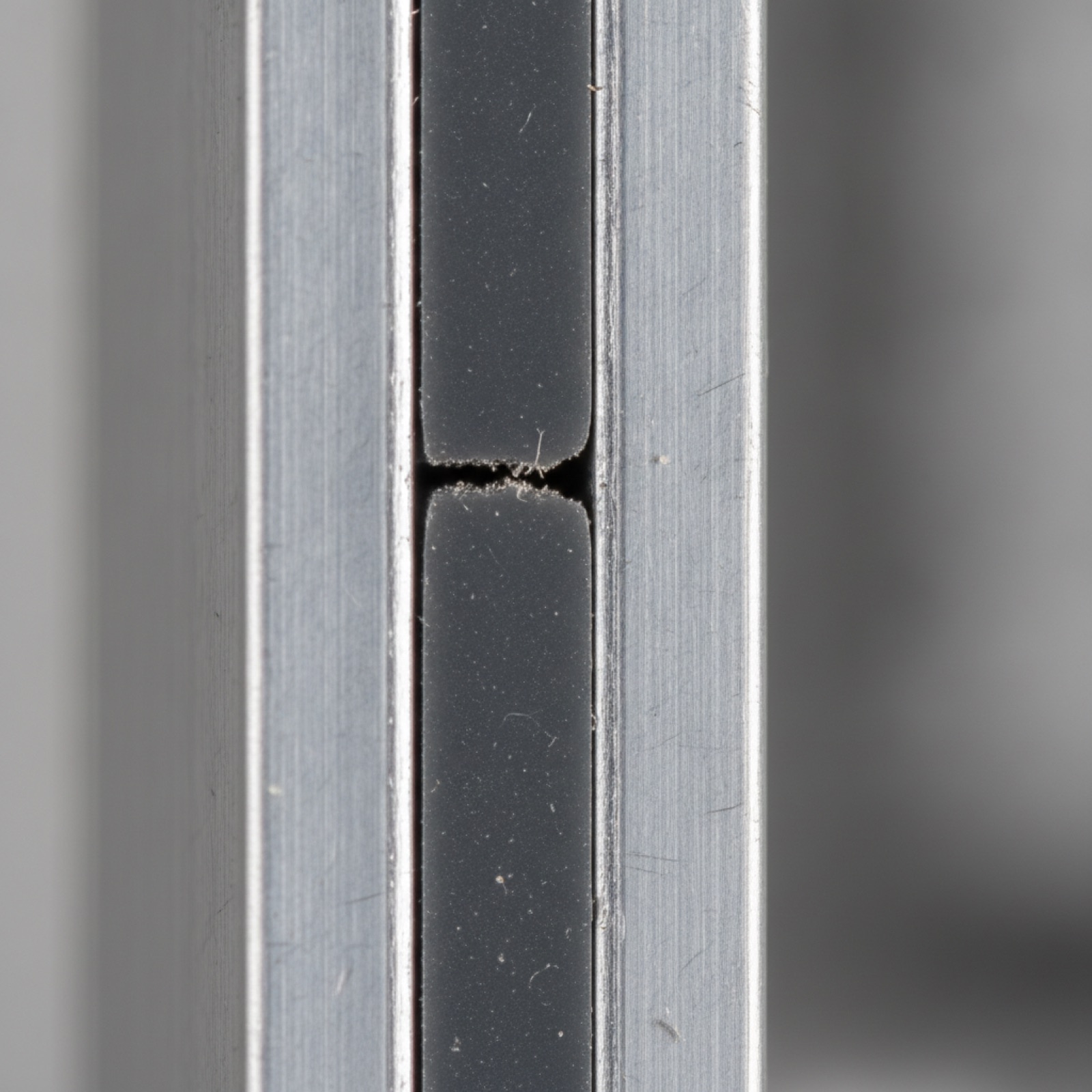 Macro cross-section of aluminum mullion with thermal-break polymer strut visible between sections