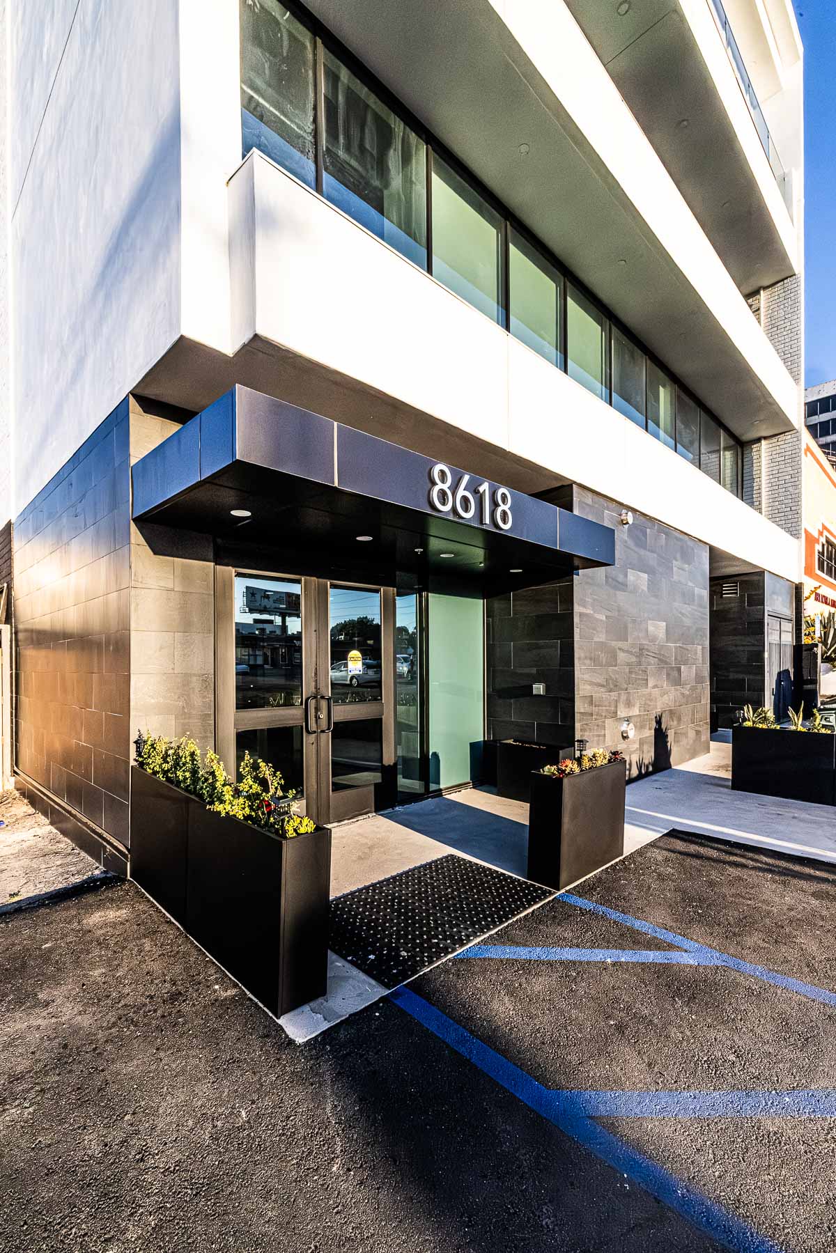 The modern entrance of the Osborne Head & Neck Institute features glass storefront doors, large windows, and dark aluminum panels.