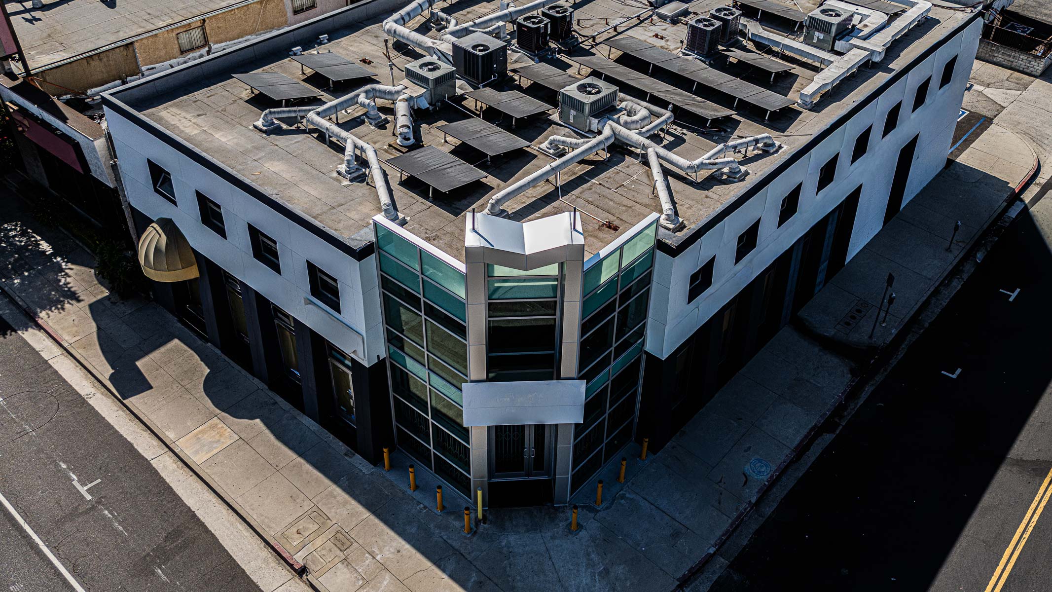 An aerial view shows the exterior corner of a commercial building featuring a newly installed glass curtainwall system.