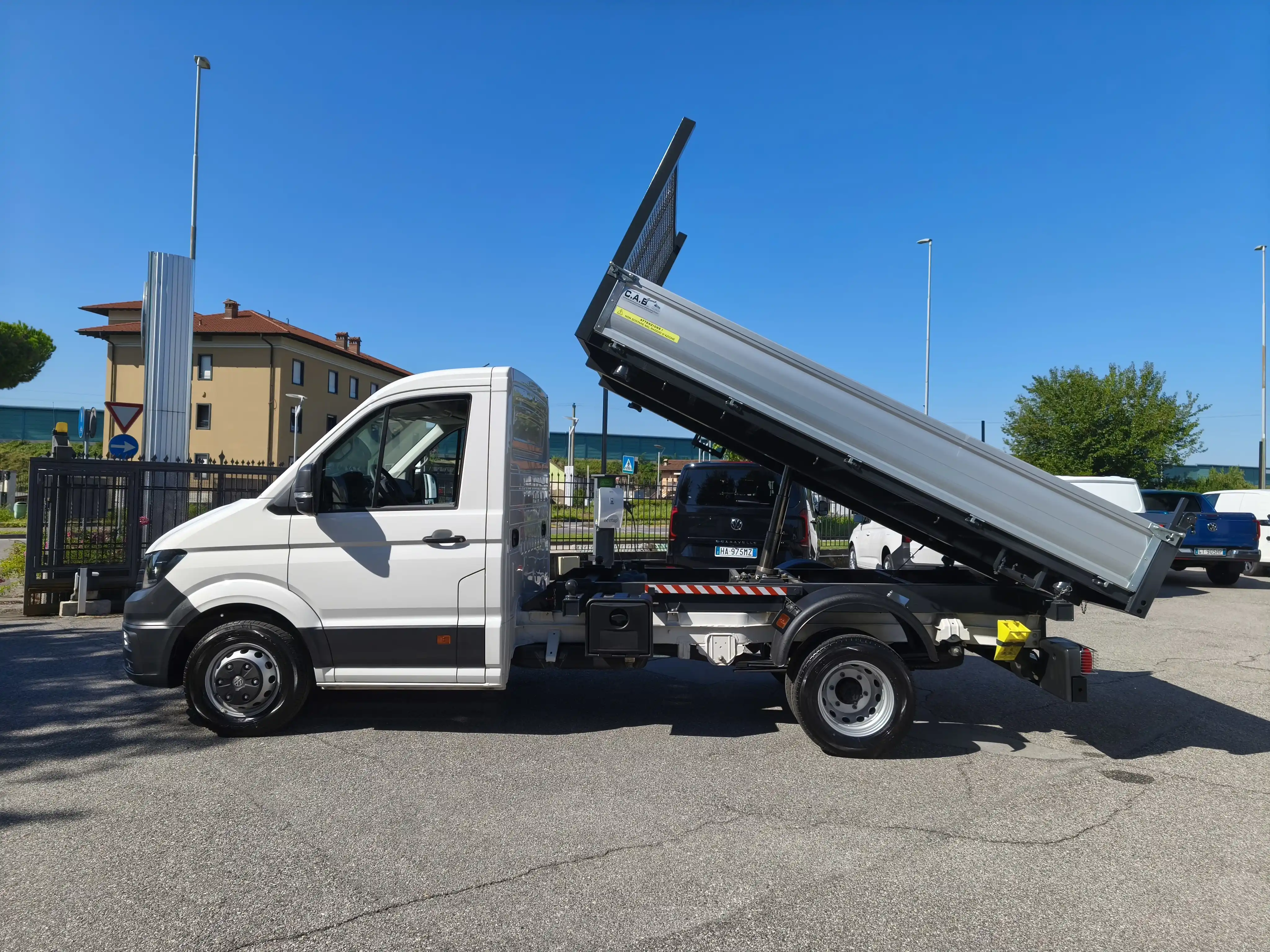 Autocarro con cassone ribaltabile bianco con la cassone ribaltata.