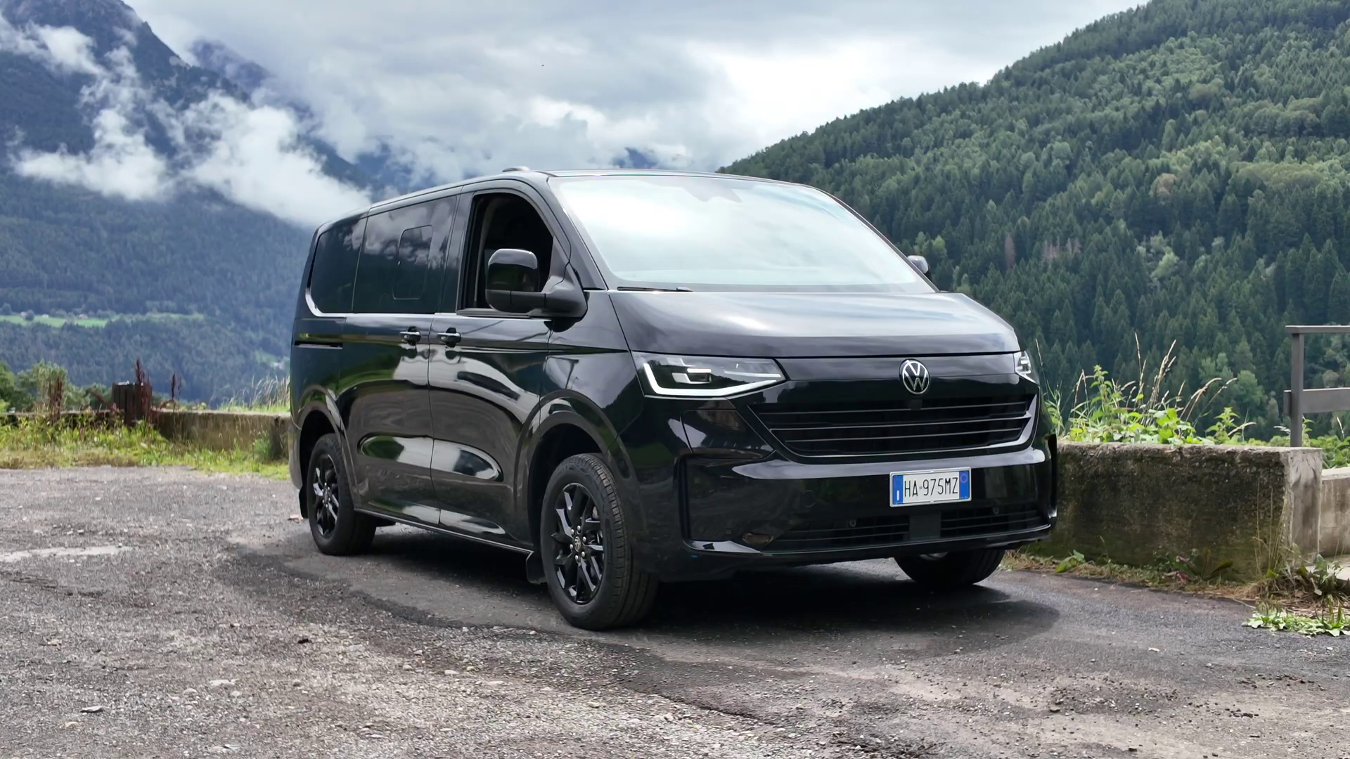 Volkswagen Multivan parcheggiato sul lato della strada in montagna.