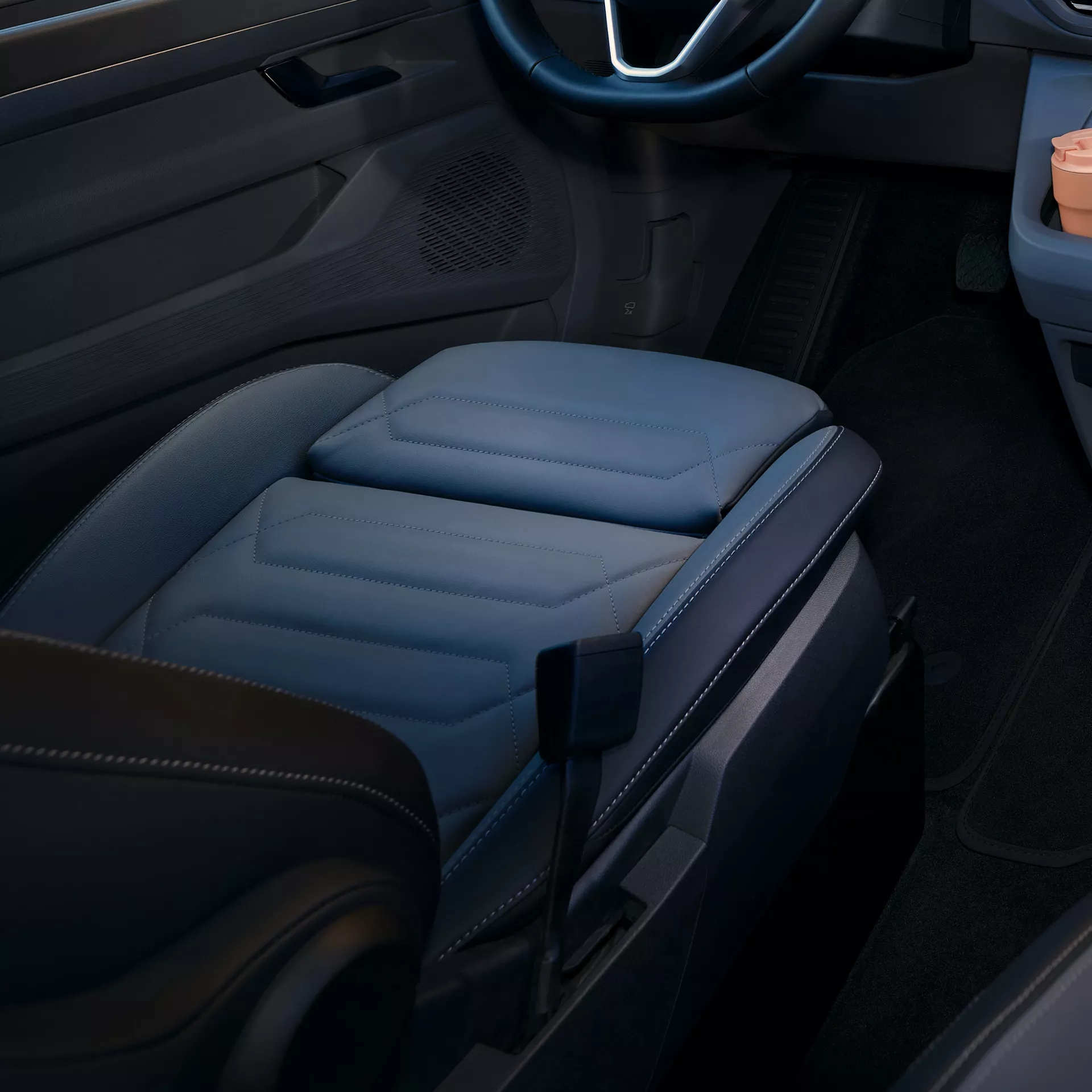 Primo piano degli interni di un'auto, con sedili in pelle e cuciture elaborate.