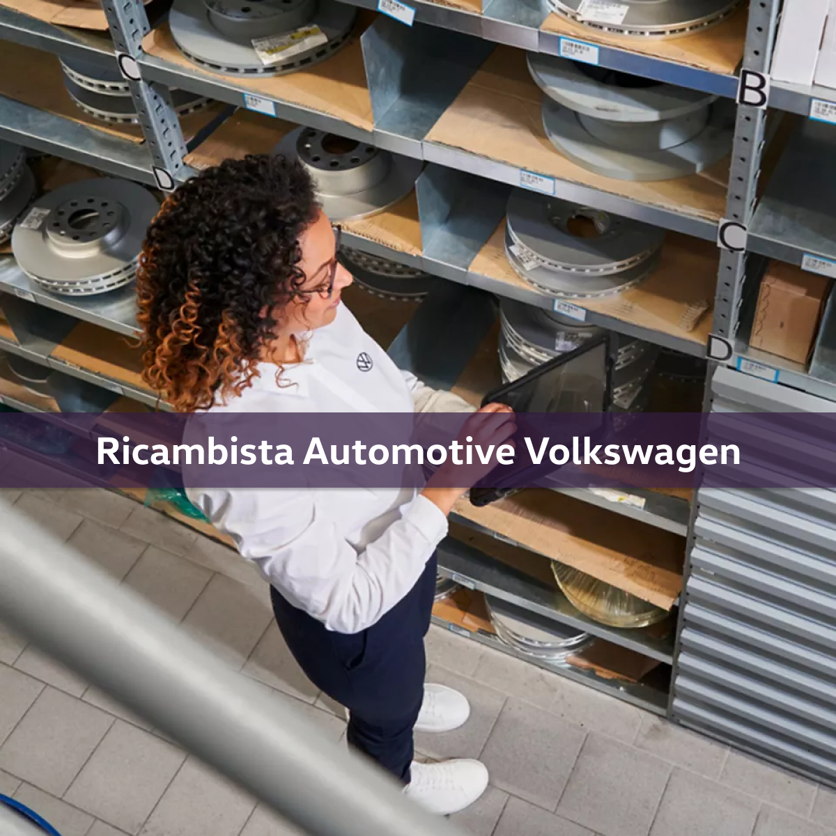 Una ricambista automotive Volkswagen al lavoro nel magazzino ricambi.