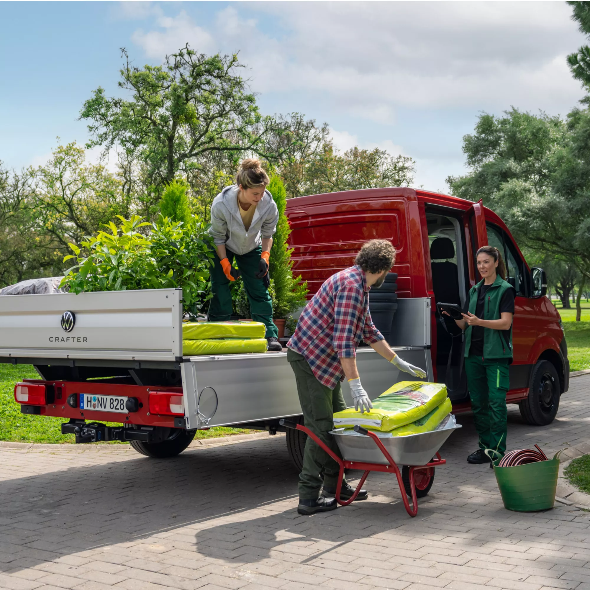 Foto di gruppo di giardinieri mentre carico del materiale su Volkswagen Crafter versione camioncino