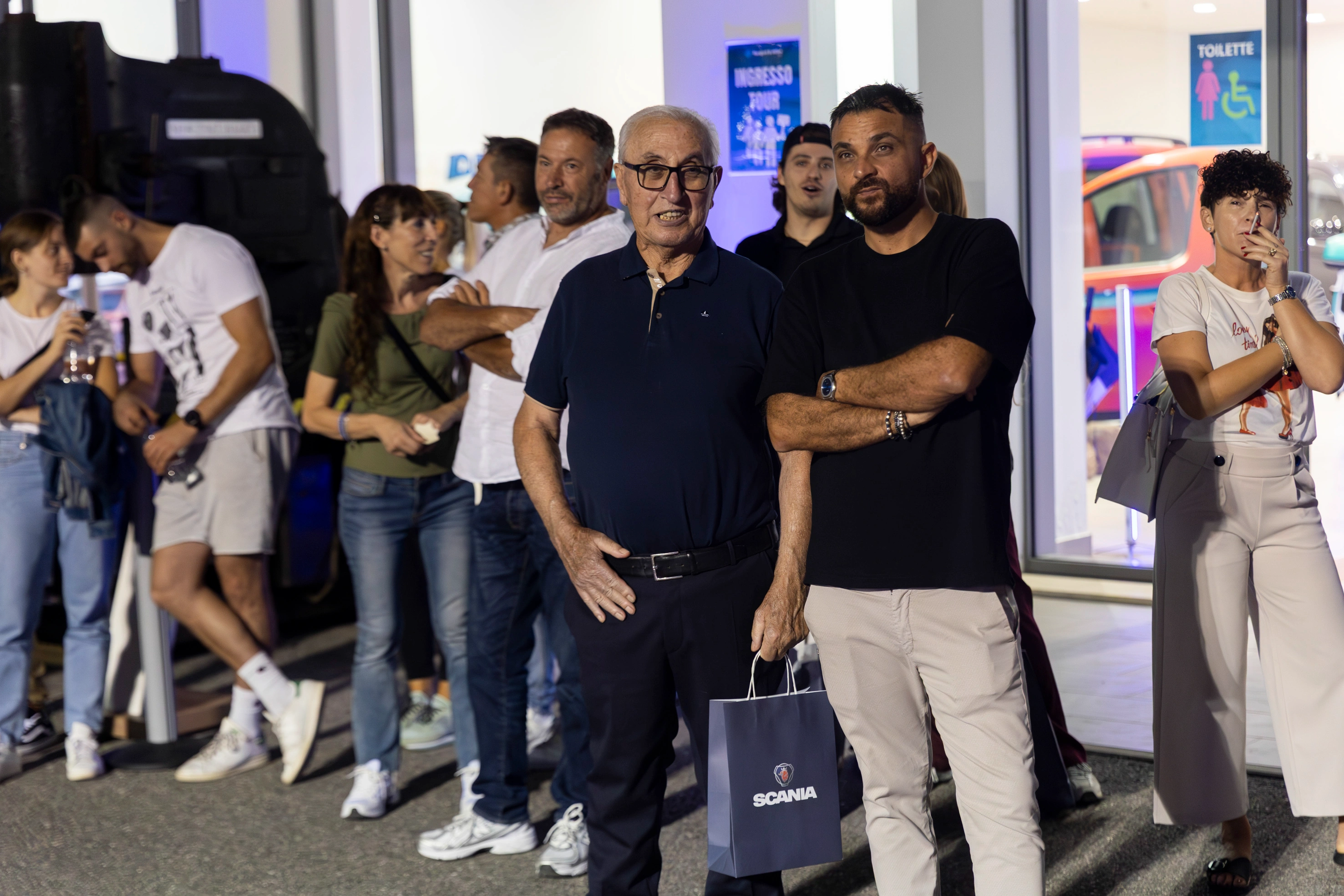 Un gruppo di persone in piedi all'aperto vicino a un edificio.