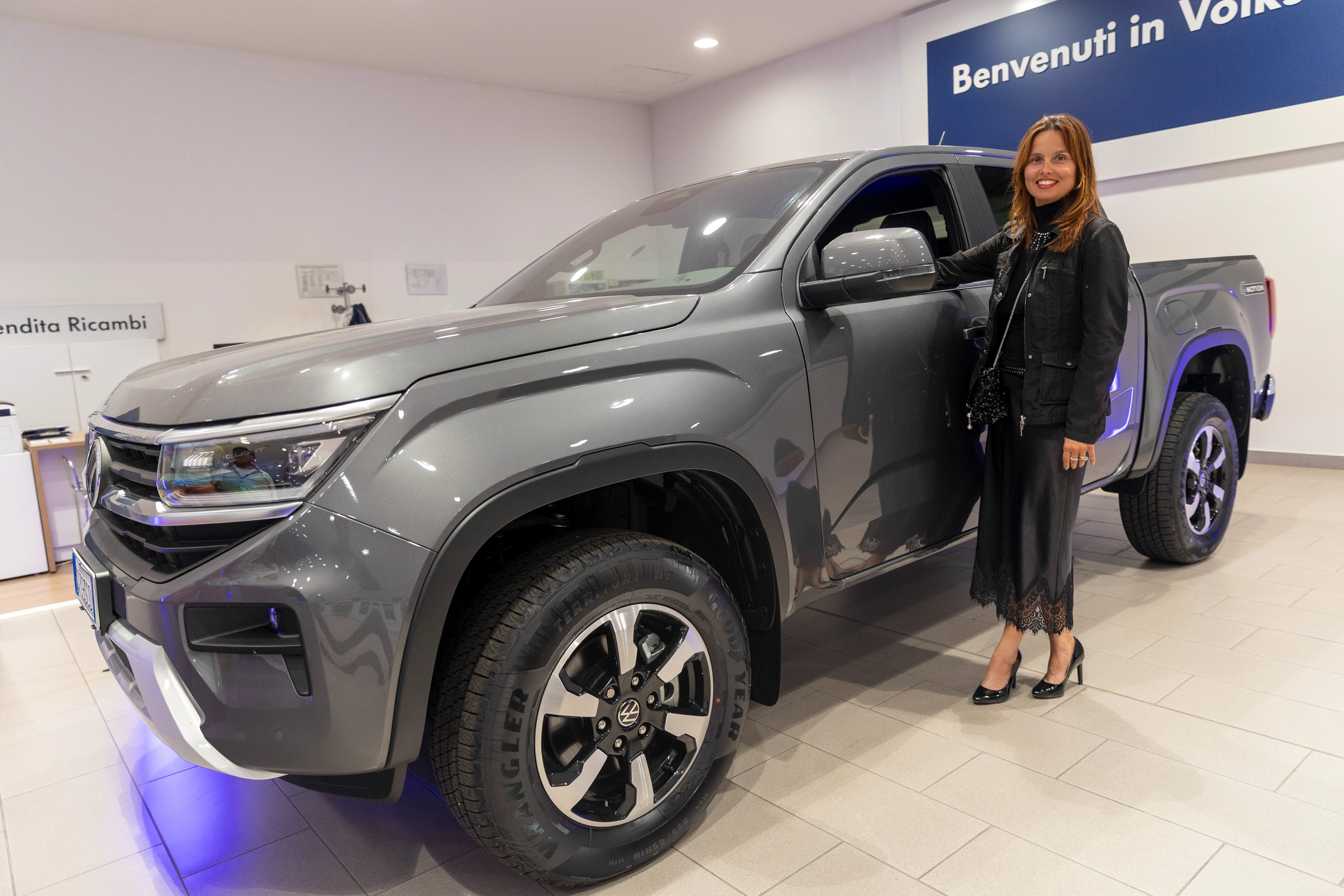 Una donna in posa accanto a un elegante pick-up Volkswagen.