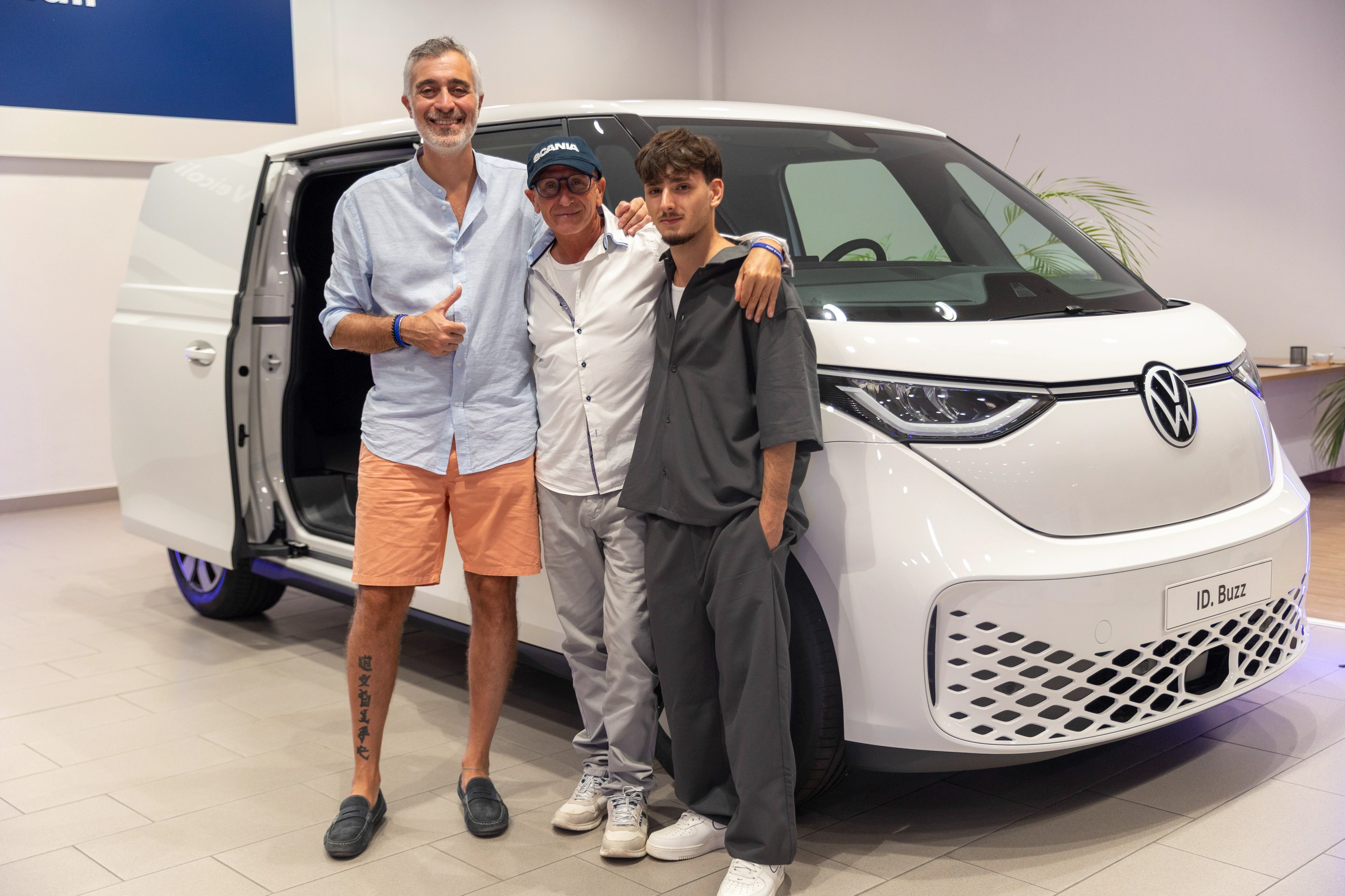 Tre uomini in posa davanti a un VW ID. Buzz.