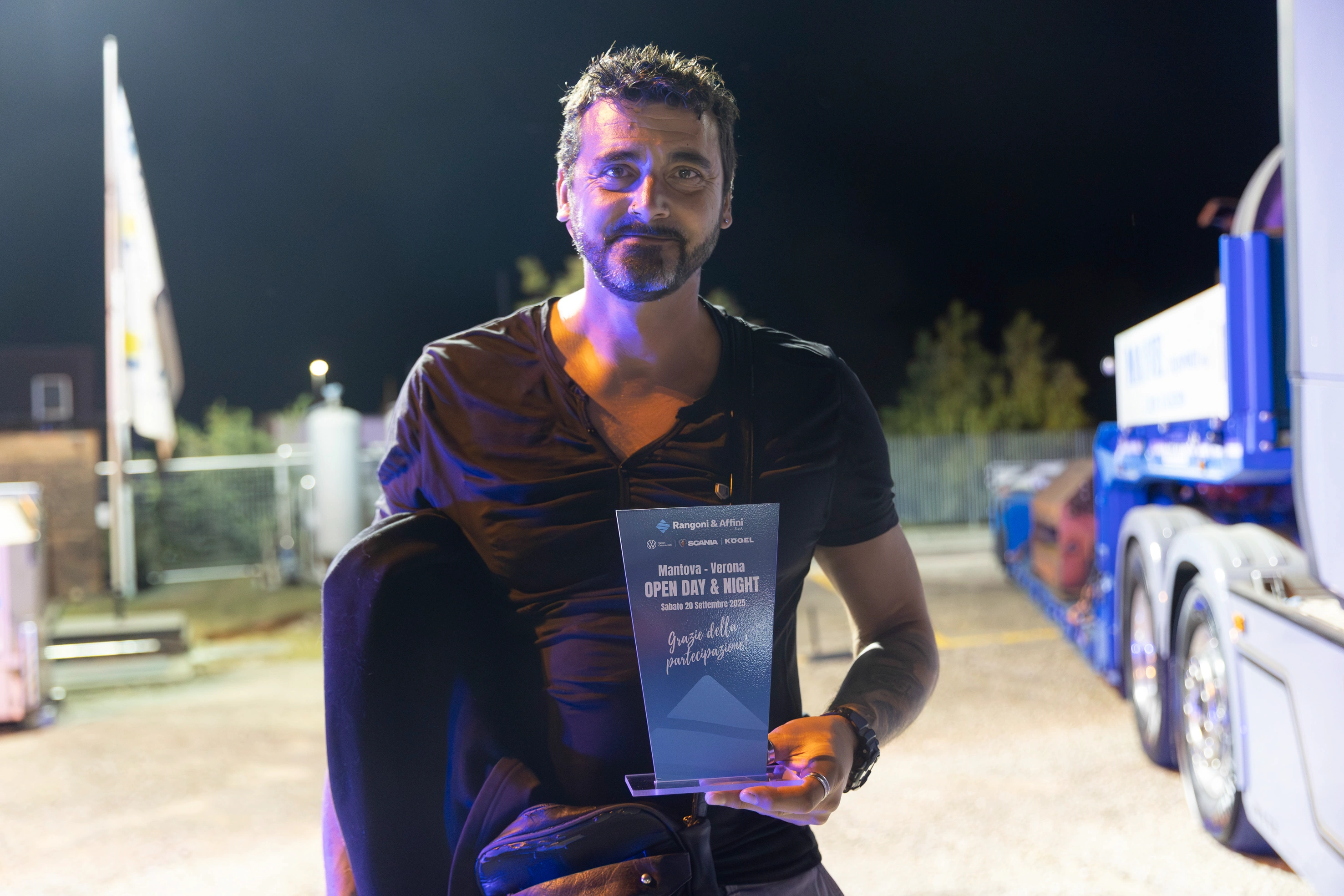 Un uomo tiene in mano un premio "Open Day & Night".