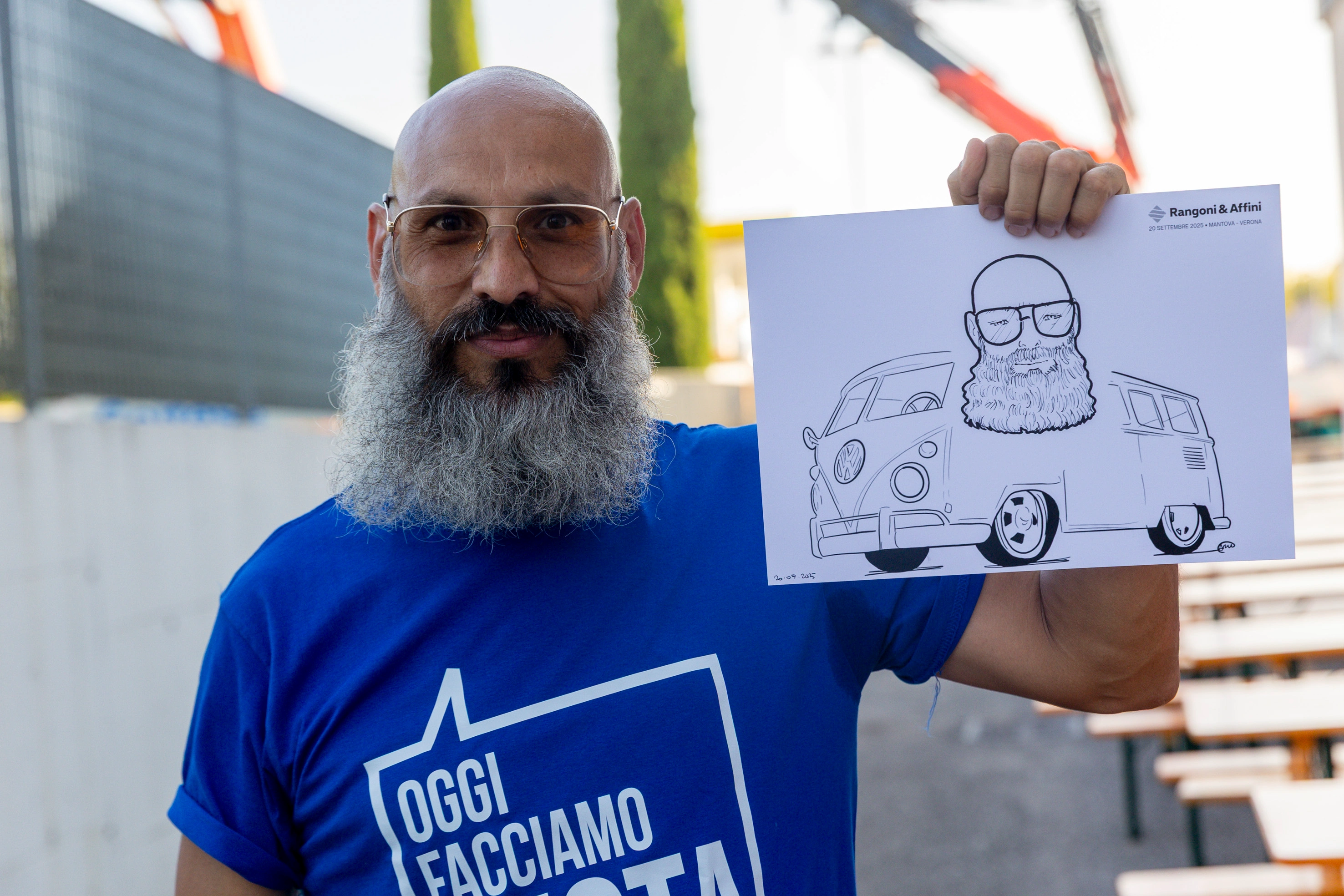 Uomo con barba tiene un disegno di sé stesso su un furgone VW.