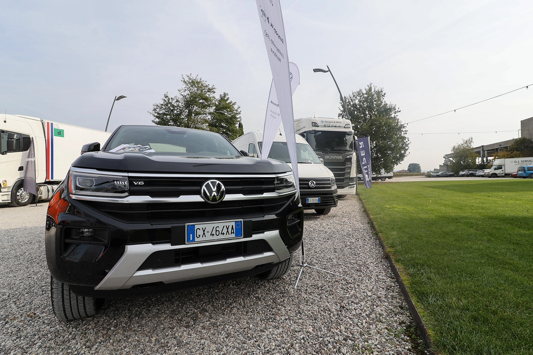 Una fila di veicoli esposti su un terreno ghiaioso.