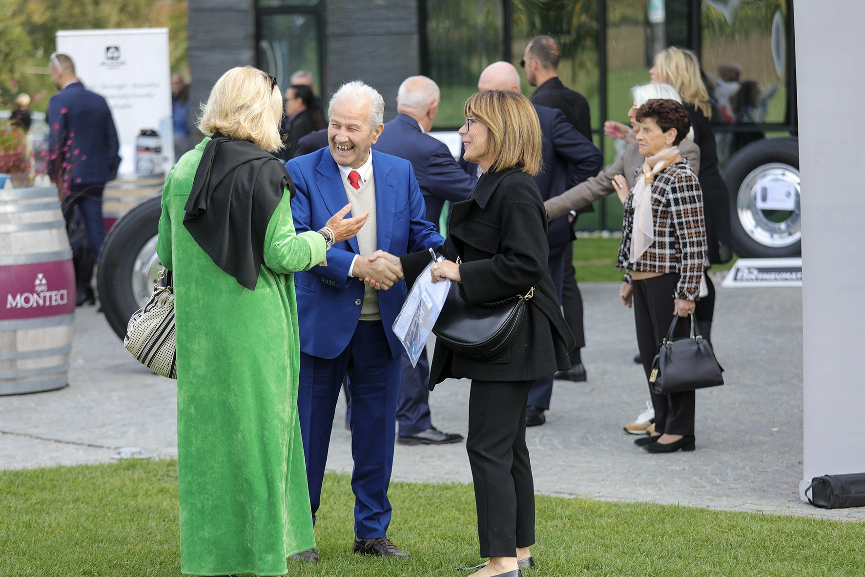 Persone si stringono la mano a un evento all'aperto.