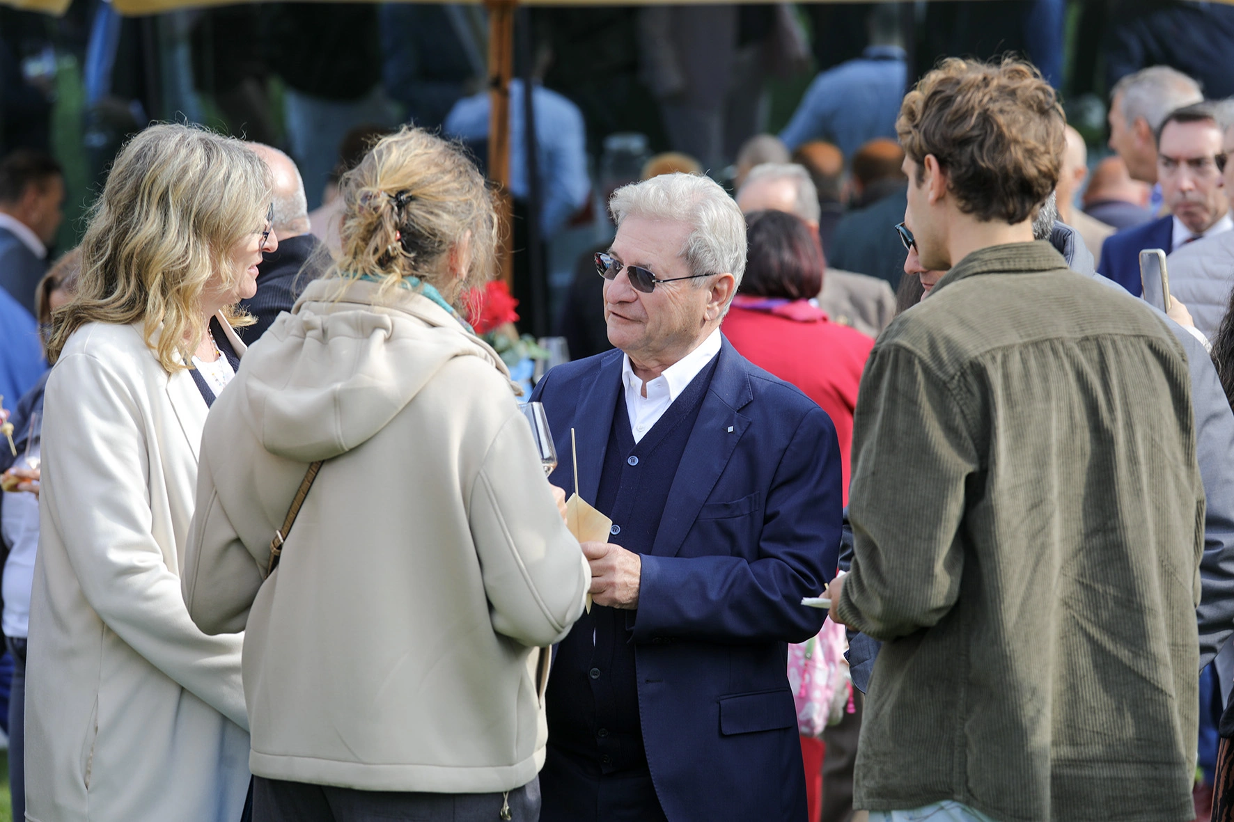 Persone che conversano a un evento all'aperto.
