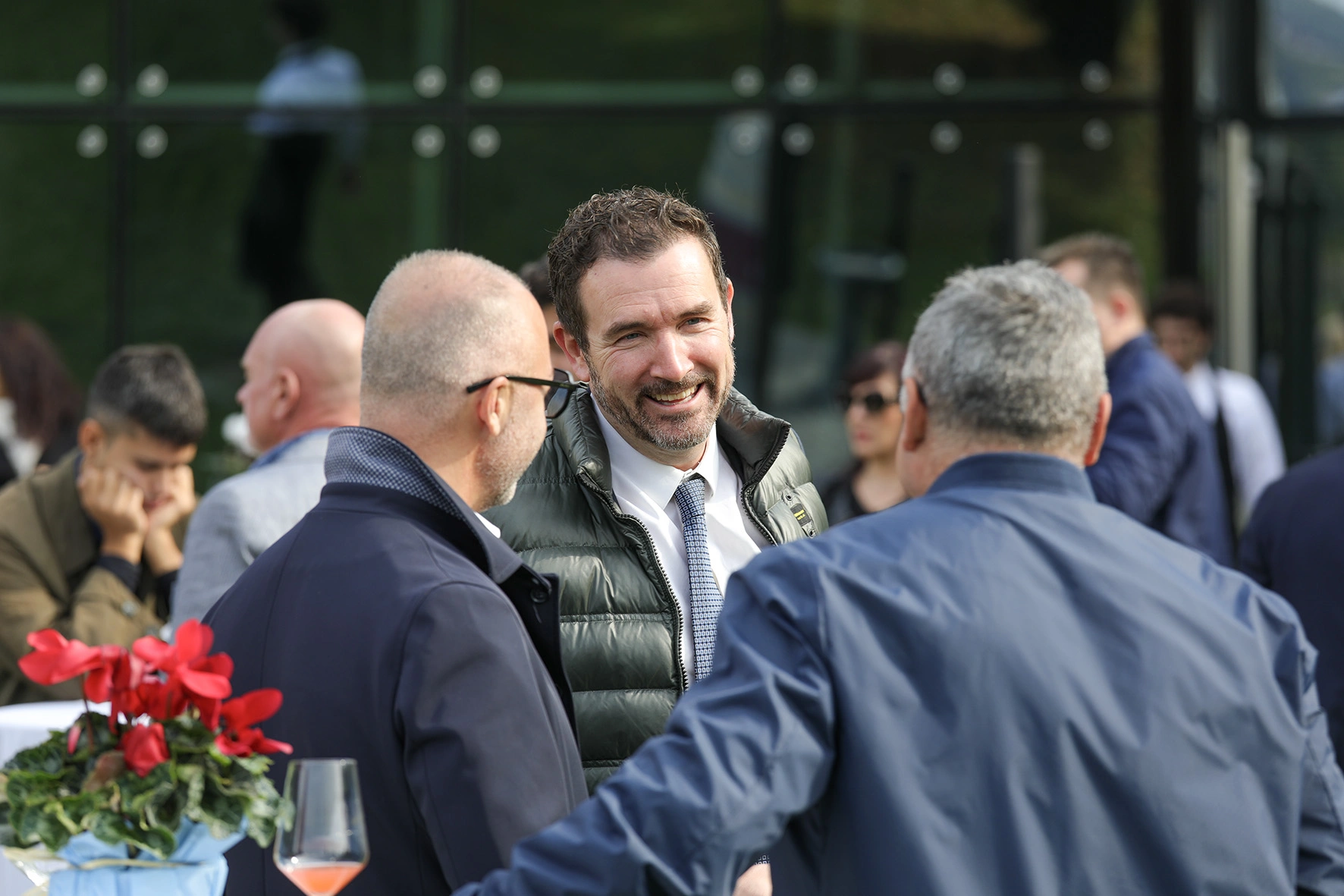 Tre uomini che parlano tra loro all'aperto.