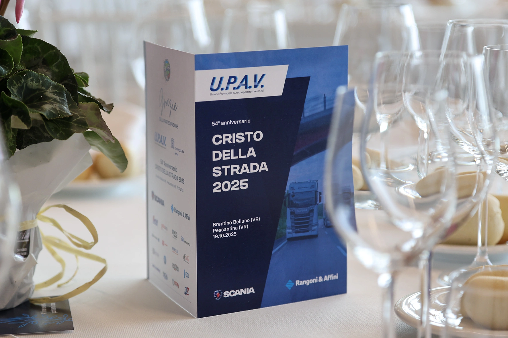 Un cartello che celebra il 54° anniversario di "Cristo della Strada 2025" con loghi Scania e Rangoni & Affini.