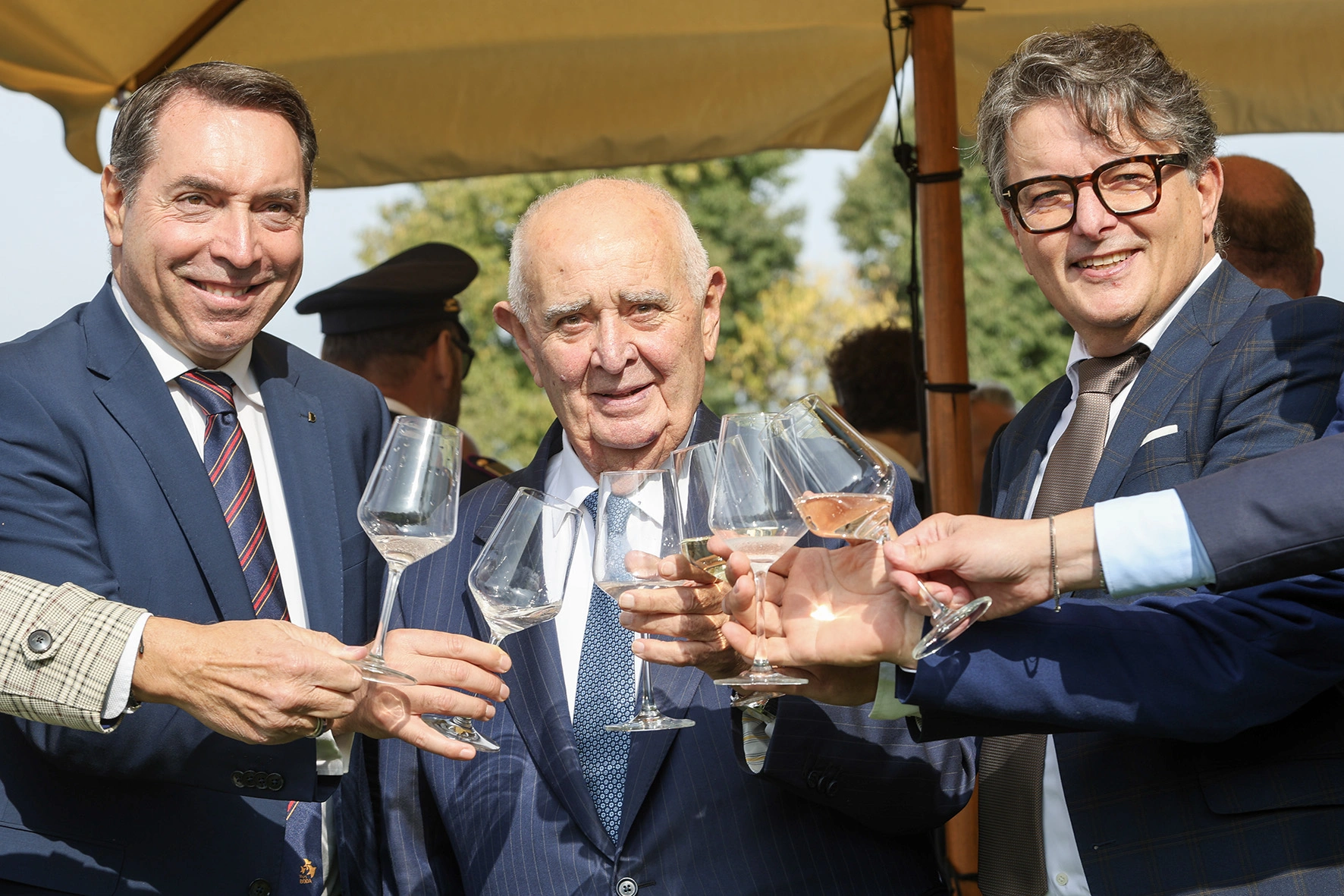 Uomini che brindano con bicchieri di vino.