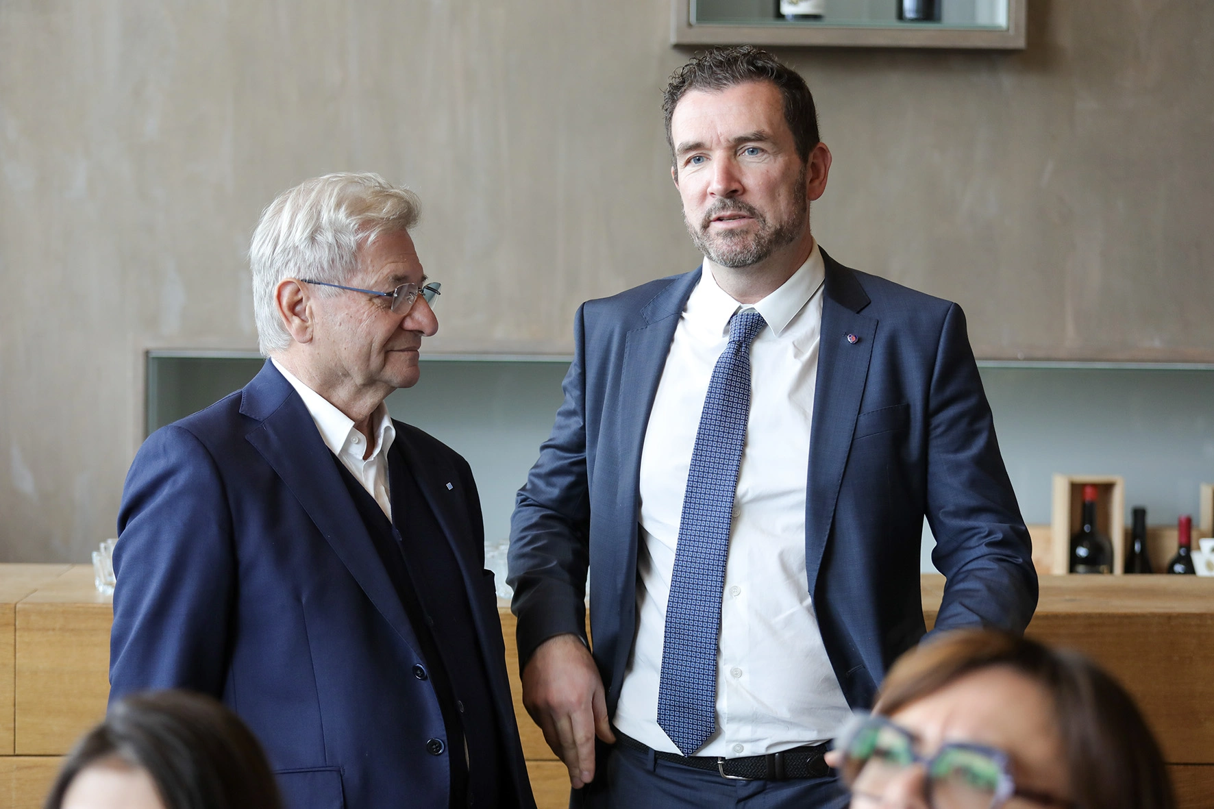 Due uomini in abiti da lavoro si trovano uno accanto all'altro.