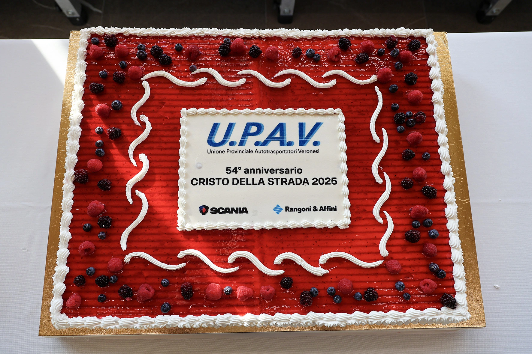 Una torta con le parole "U.P.A.V. Unione Provinciale Autotrasportatori Veronesi 54° anniversario CRISTO DELLA STRADA 2025."