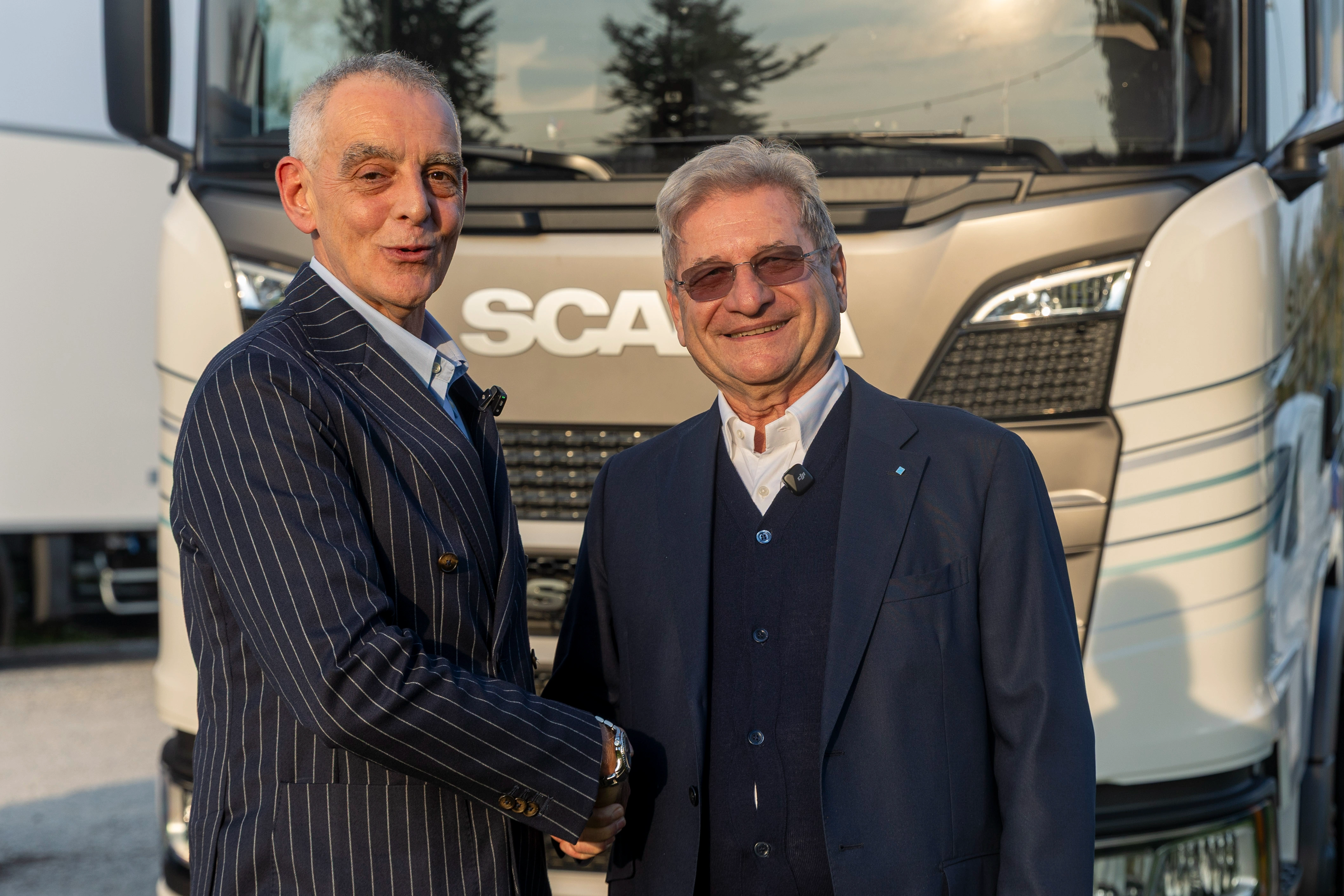 Due uomini stringono la mano davanti a un camion SCANIA.