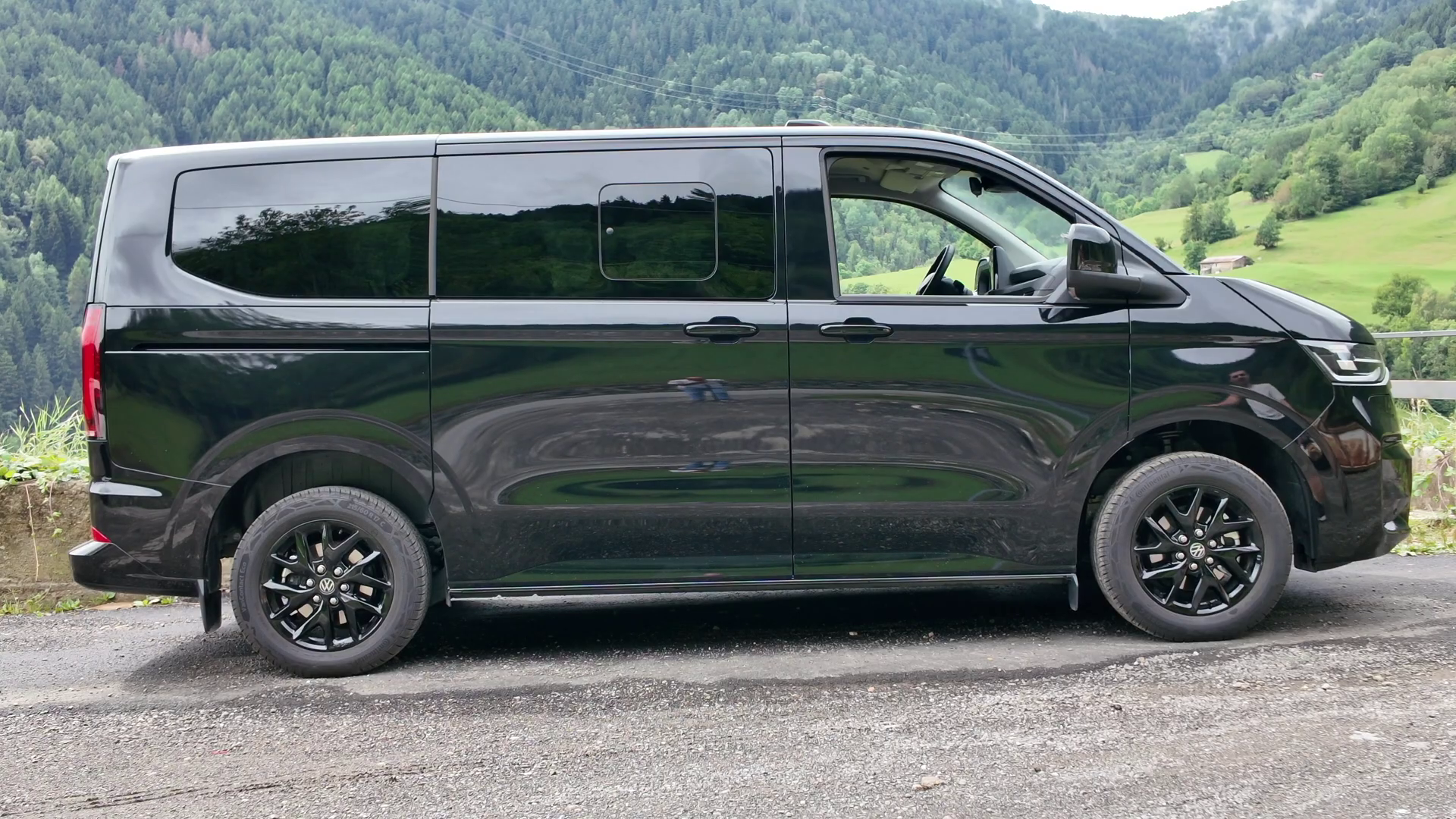 Un furgone Volkswagen nero parcheggiato su una strada di campagna.