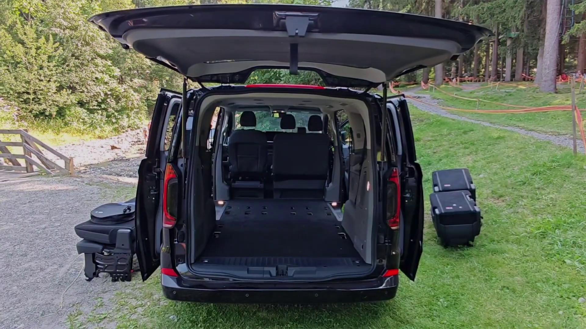 Un furgone nero con le portiere e il bagagliaio aperti.