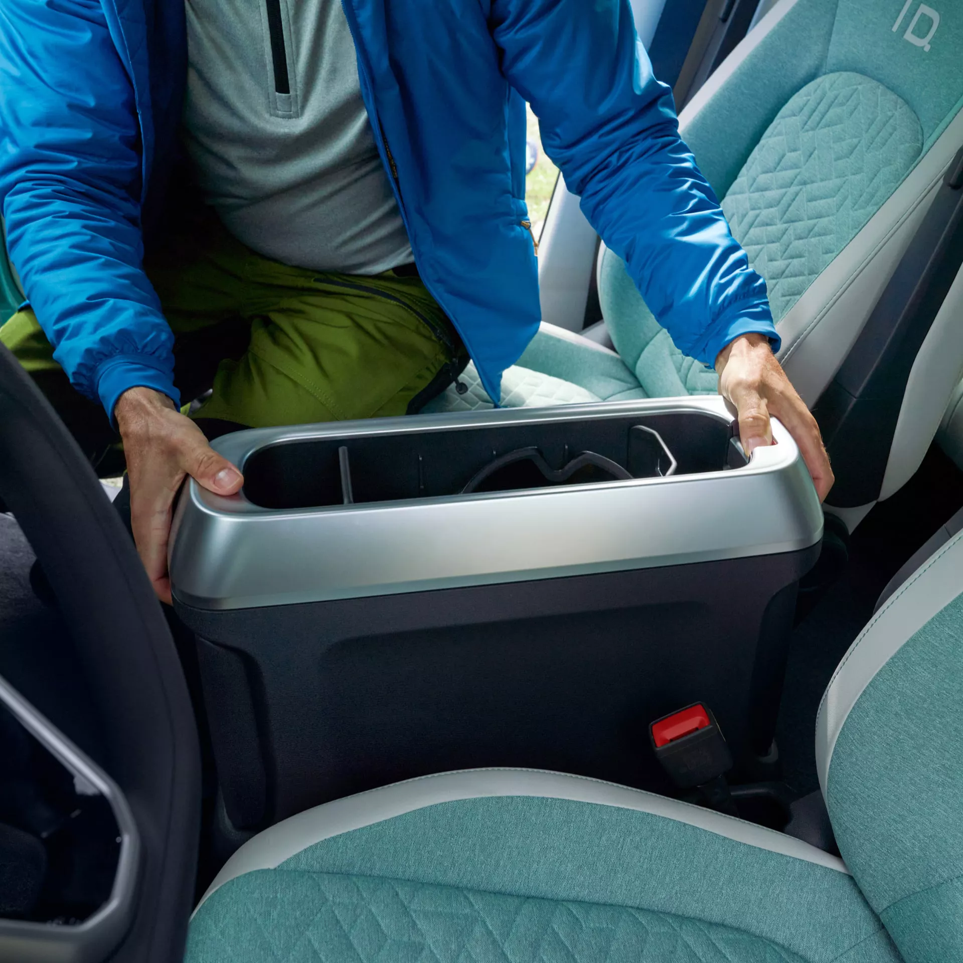 Uomo che posiziona un organizer tra i sedili dell'auto.