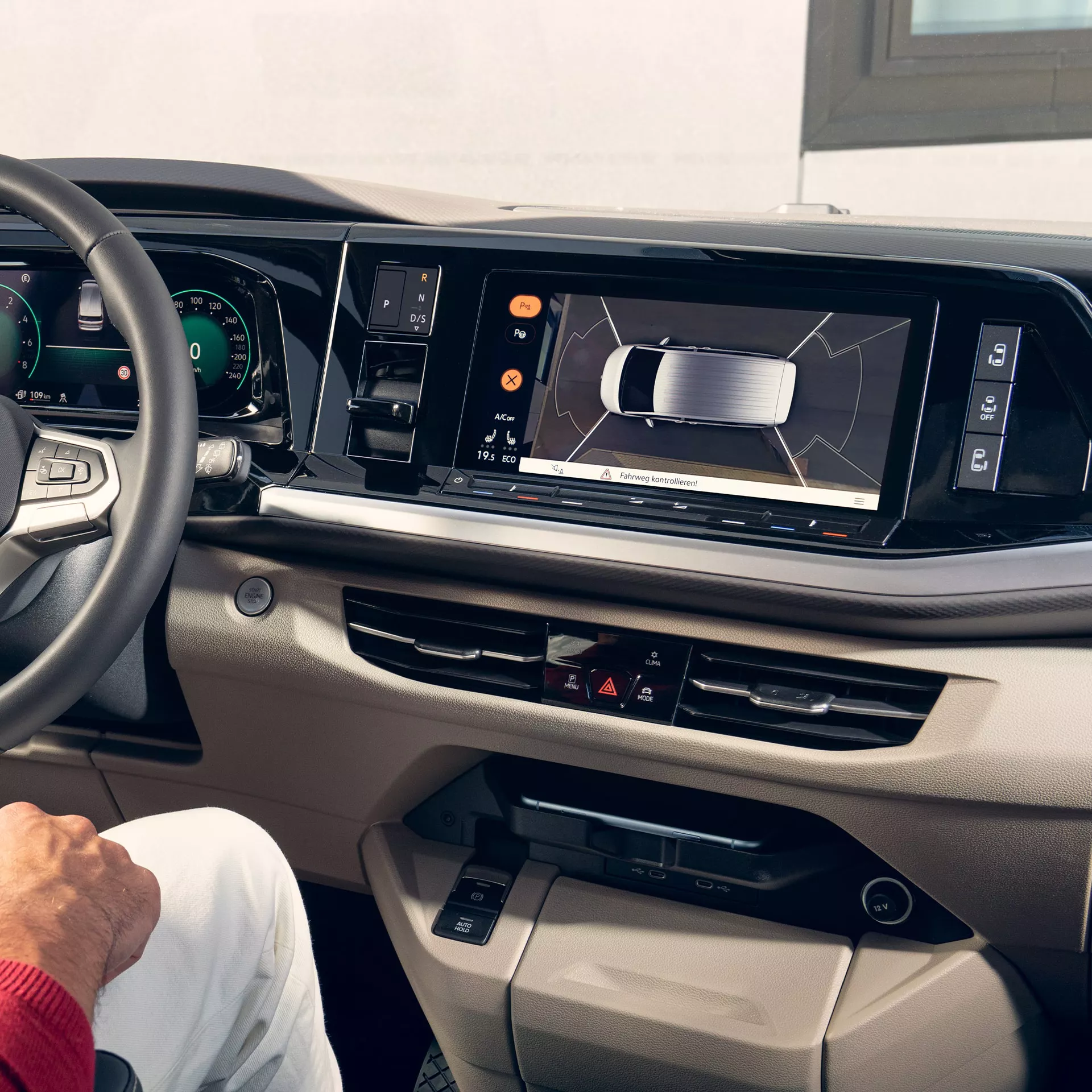 Interni di un veicolo che mostrano la dashboard e il sistema di navigazione che visualizza una vista dall'alto del veicolo.