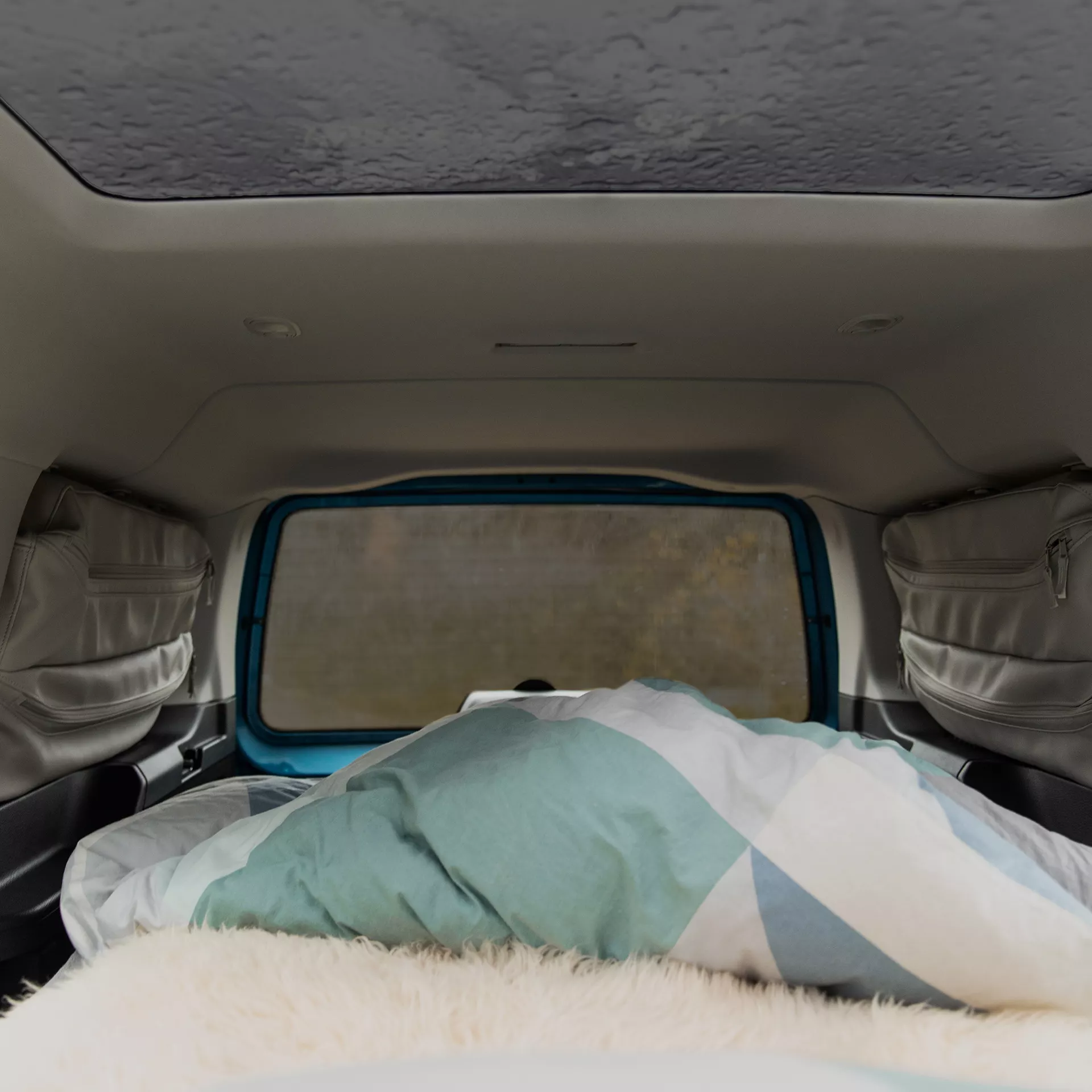 Comodo letto fatto in un furgone in una giornata di pioggia.