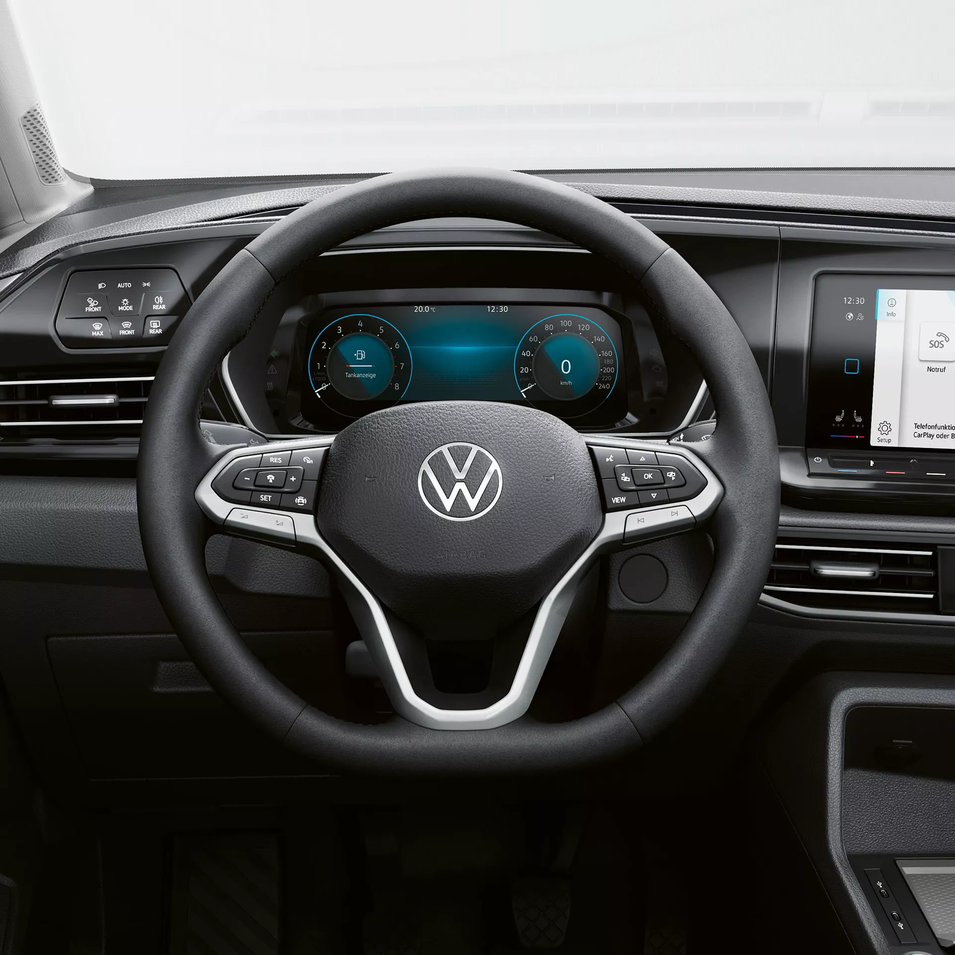 Interni moderni di un'auto Volkswagen con volante, cruscotto digitale e sistema di infotainment.