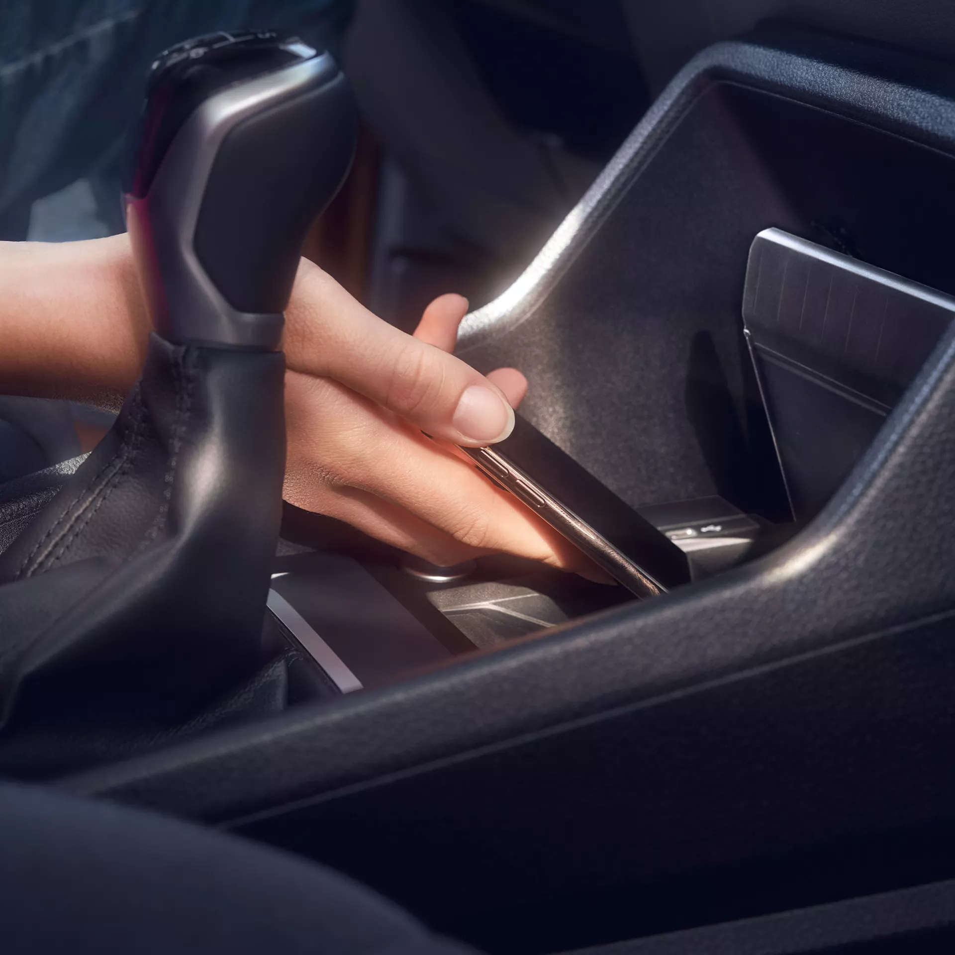 La mano di una persona che mette un telefono su un caricatore wireless.