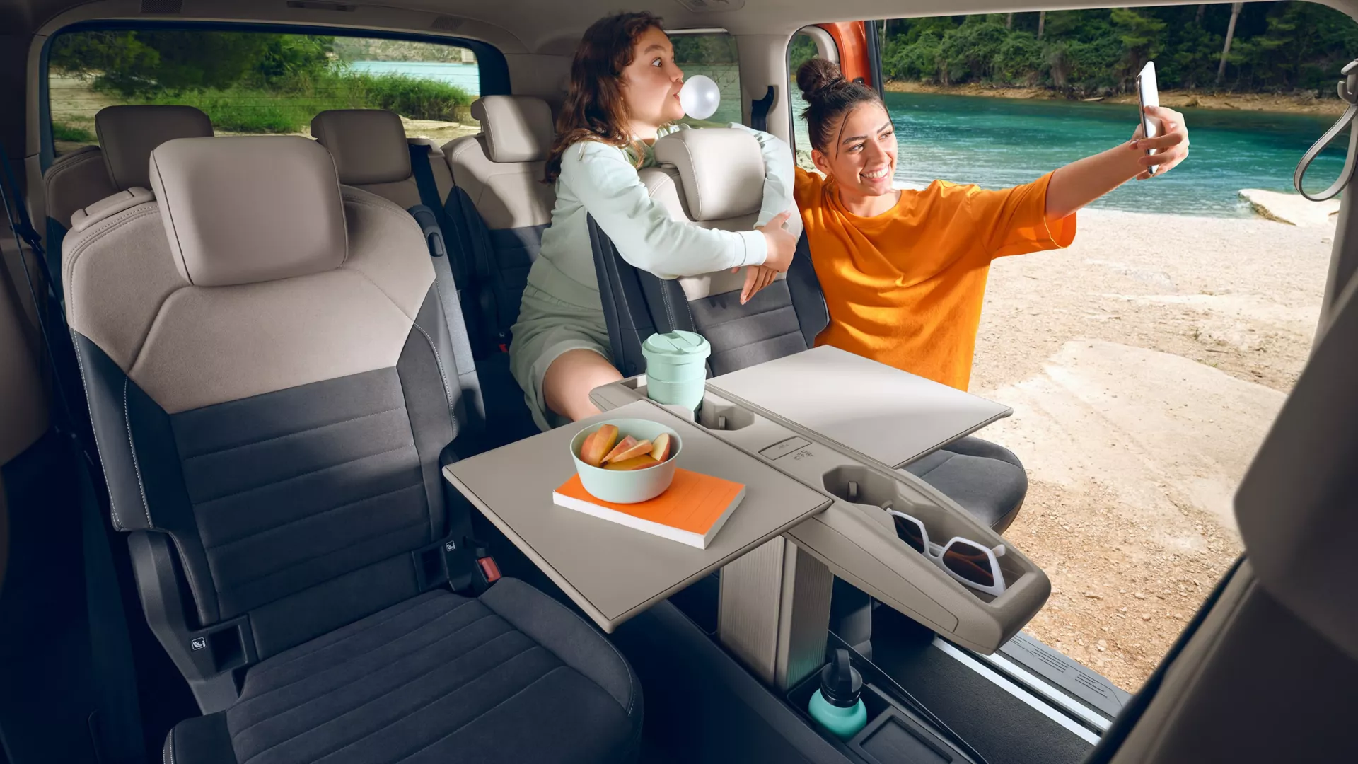 Dentro un'auto, due amiche si godono una vacanza al lago.