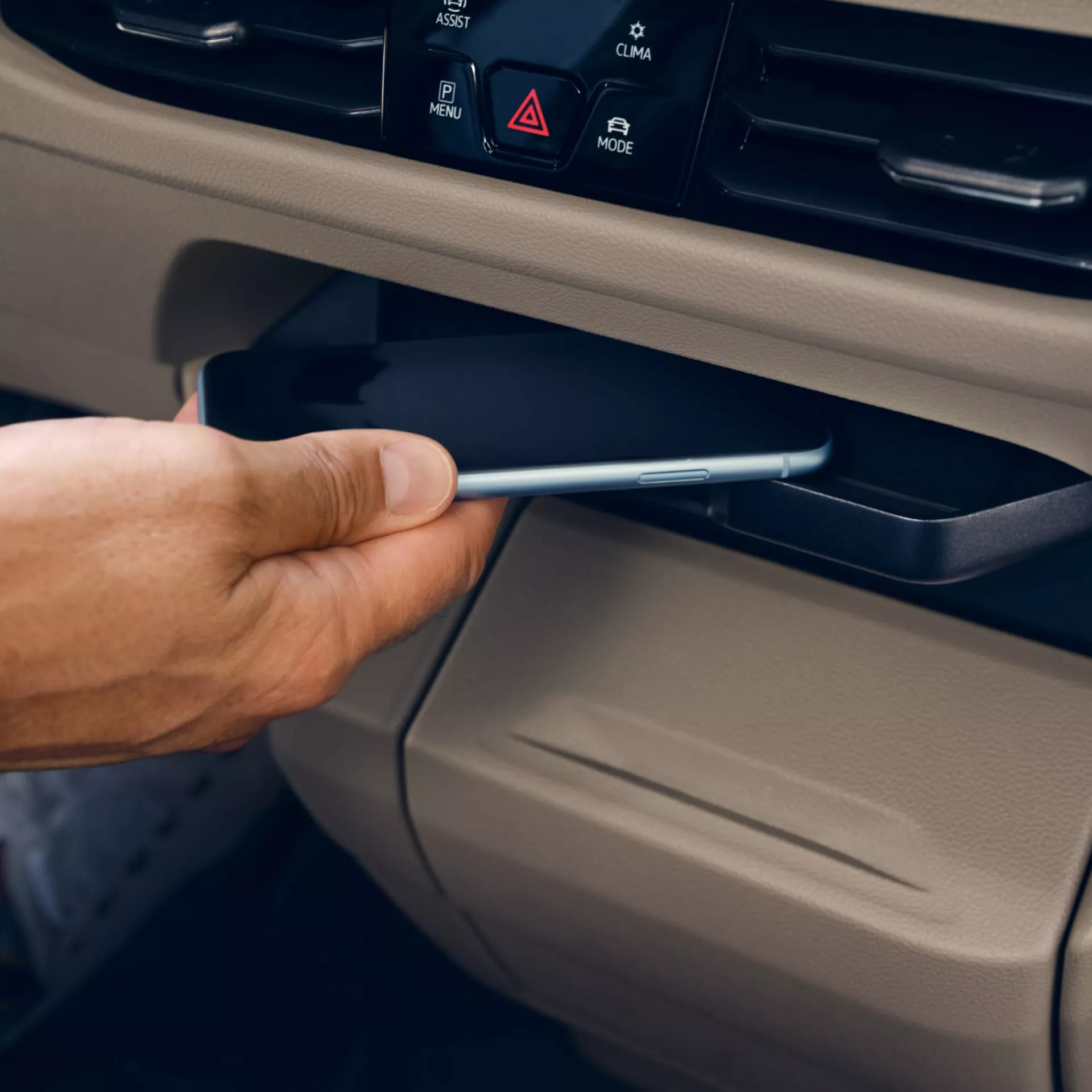 Una persona che inserisce un telefono in un porta telefono in macchina.