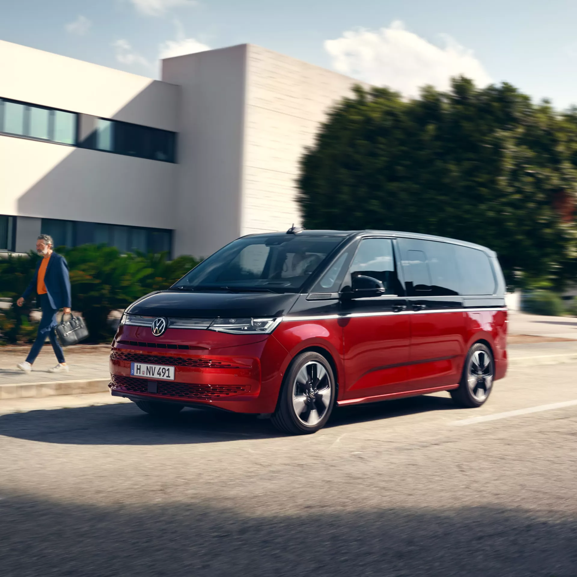 Volkswagen Multivan rosso e nero su strada.