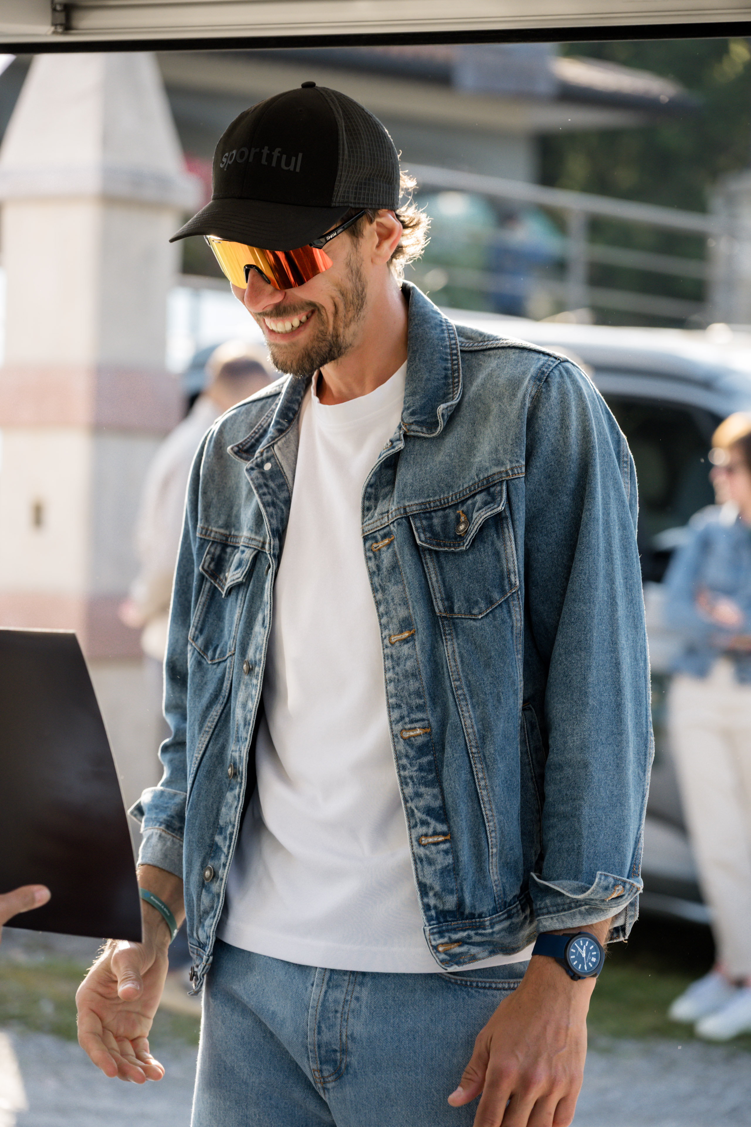 Sorriso contagioso, stile casual: cappellino Sportful, occhiali Smith e giacca di jeans.