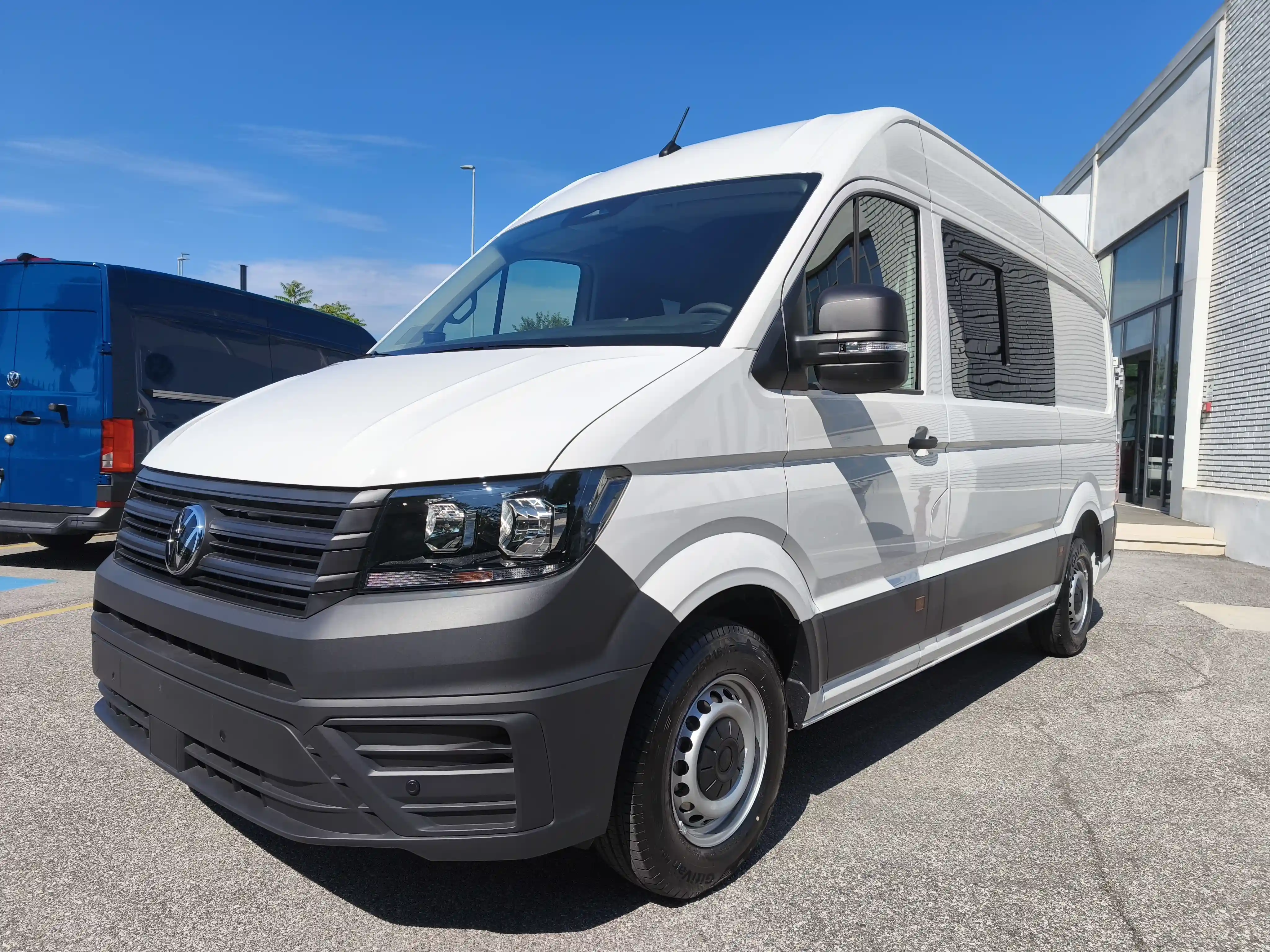 Furgone bianco Volkswagen Crafter con cielo blu.