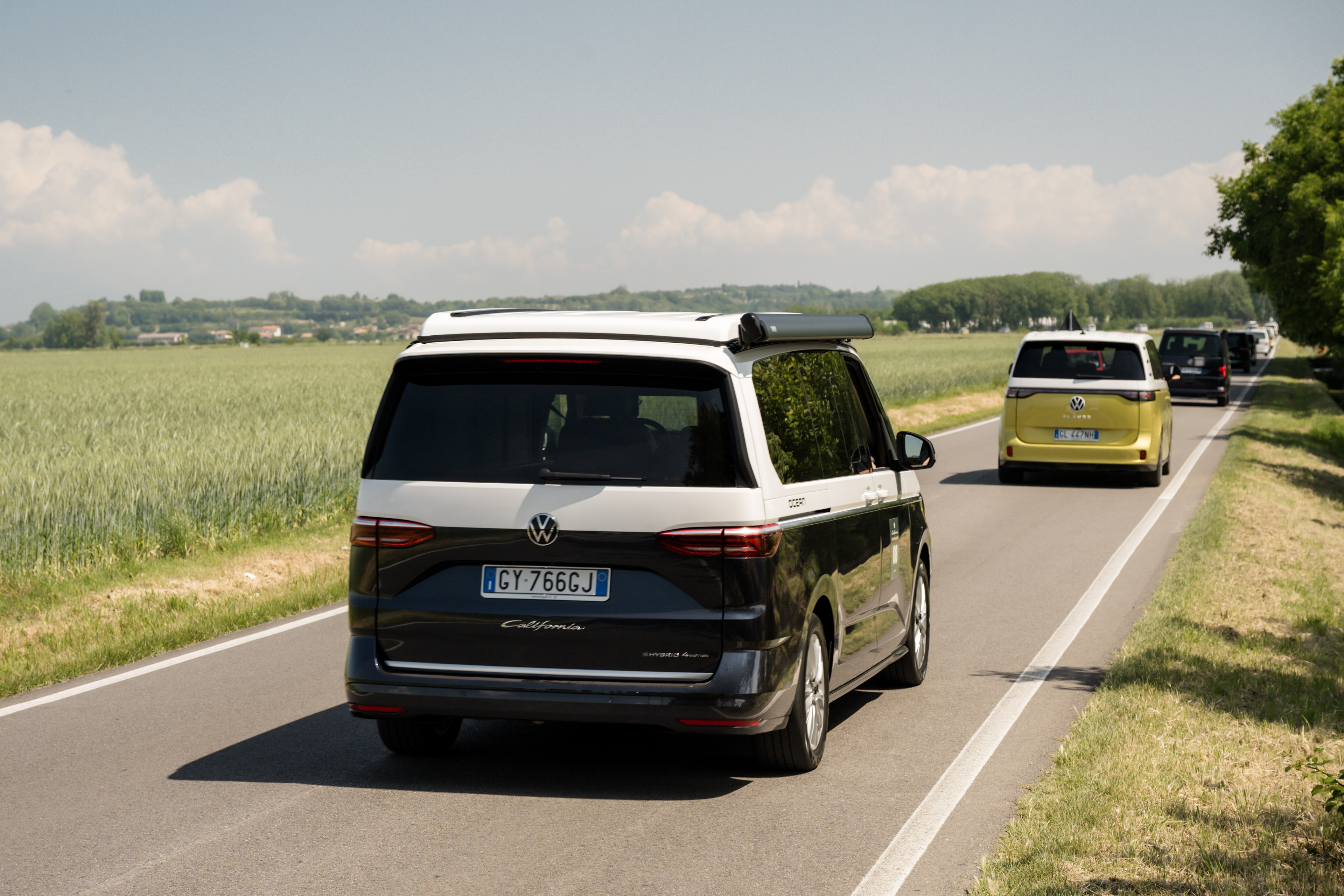 california-colline-moreniche.jpg Colorful vans wind through picturesque green hills, enjoying a sunny road trip.
