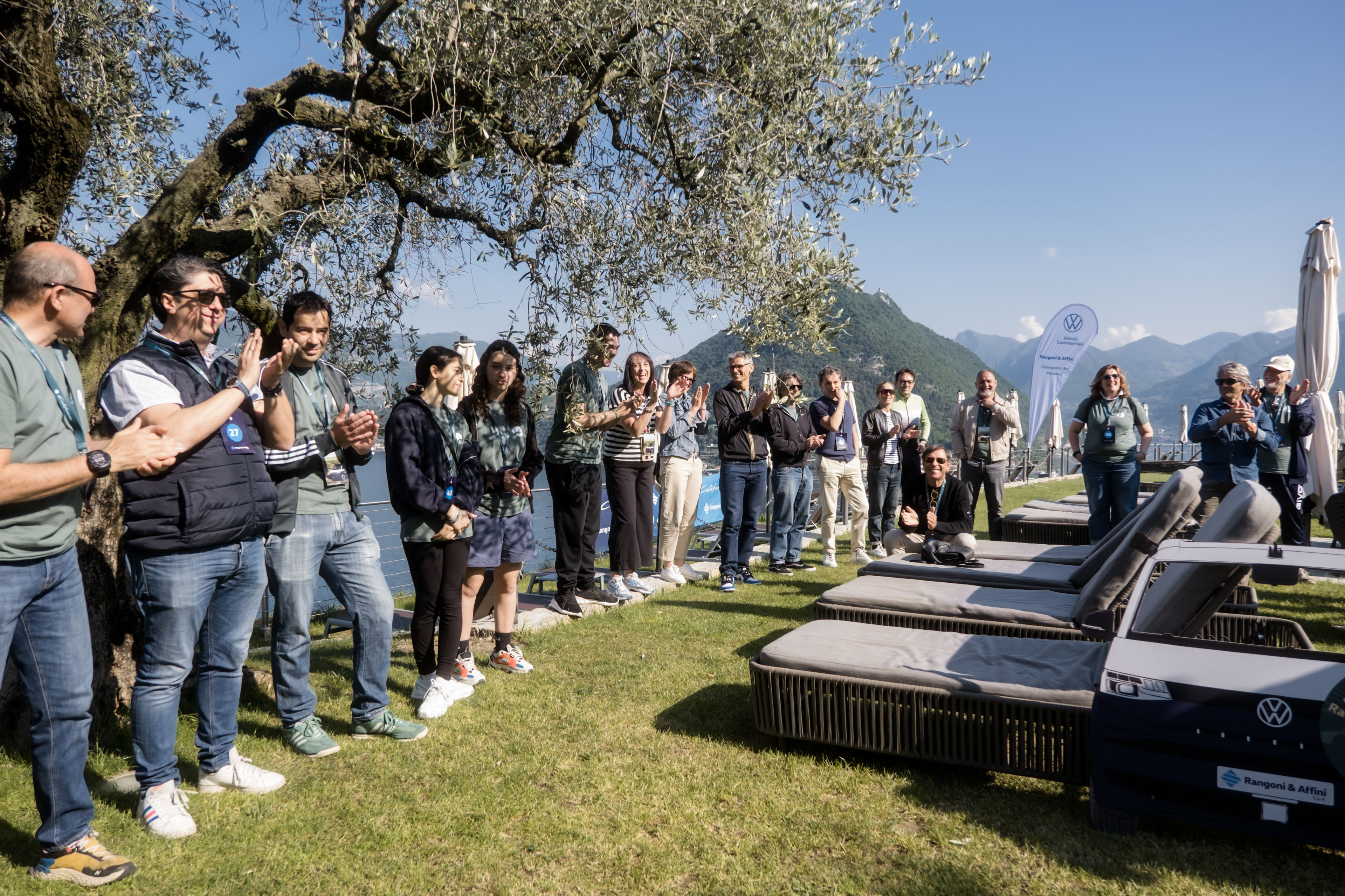 partecipanti.jpg Paesaggio lacustre mozzafiato: acque blu, montagne rigogliose e un borgo incantevole sotto un cielo sereno.