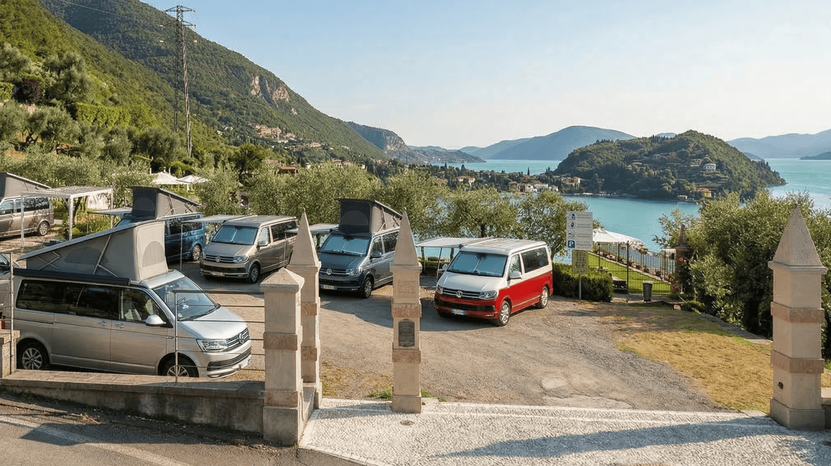 Camper con tetto a soffietto in un parcheggio panoramico. Vista mozzafiato su lago e montagne.