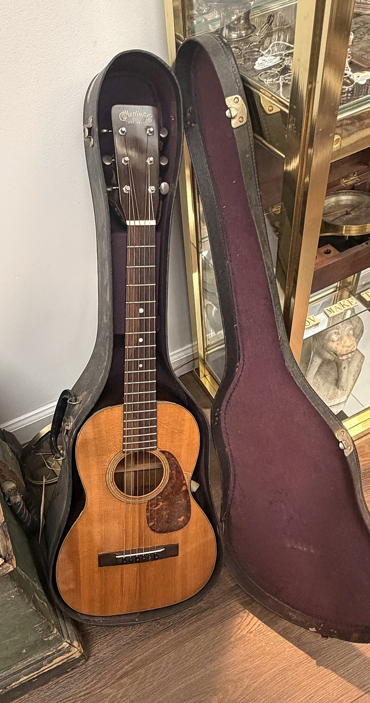 An acoustic guitar standing in its open case
