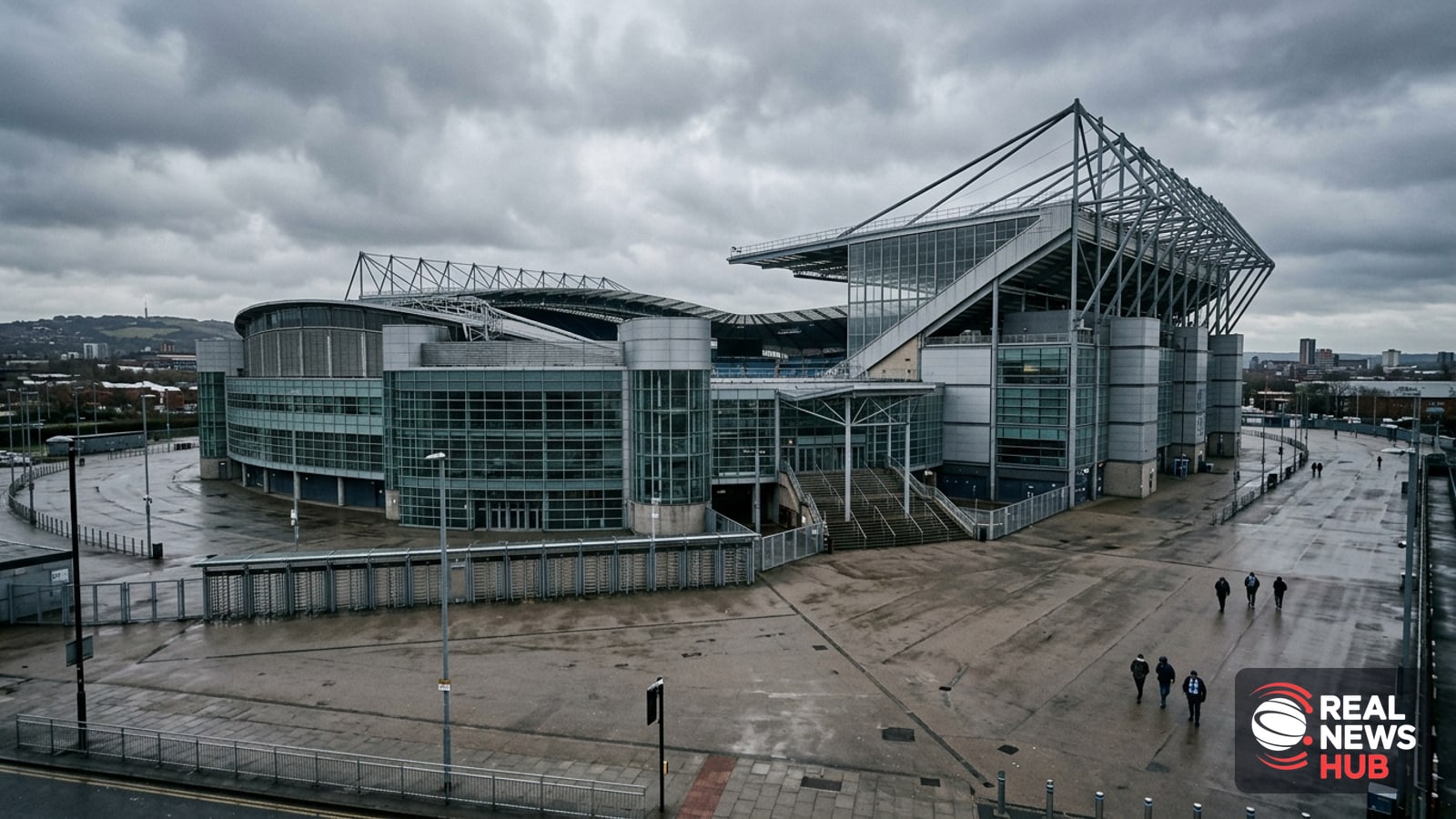 Exterior view of a modern Premier League football stadium concourse on an overcast day, with anonymous supporters walking by in the distance.